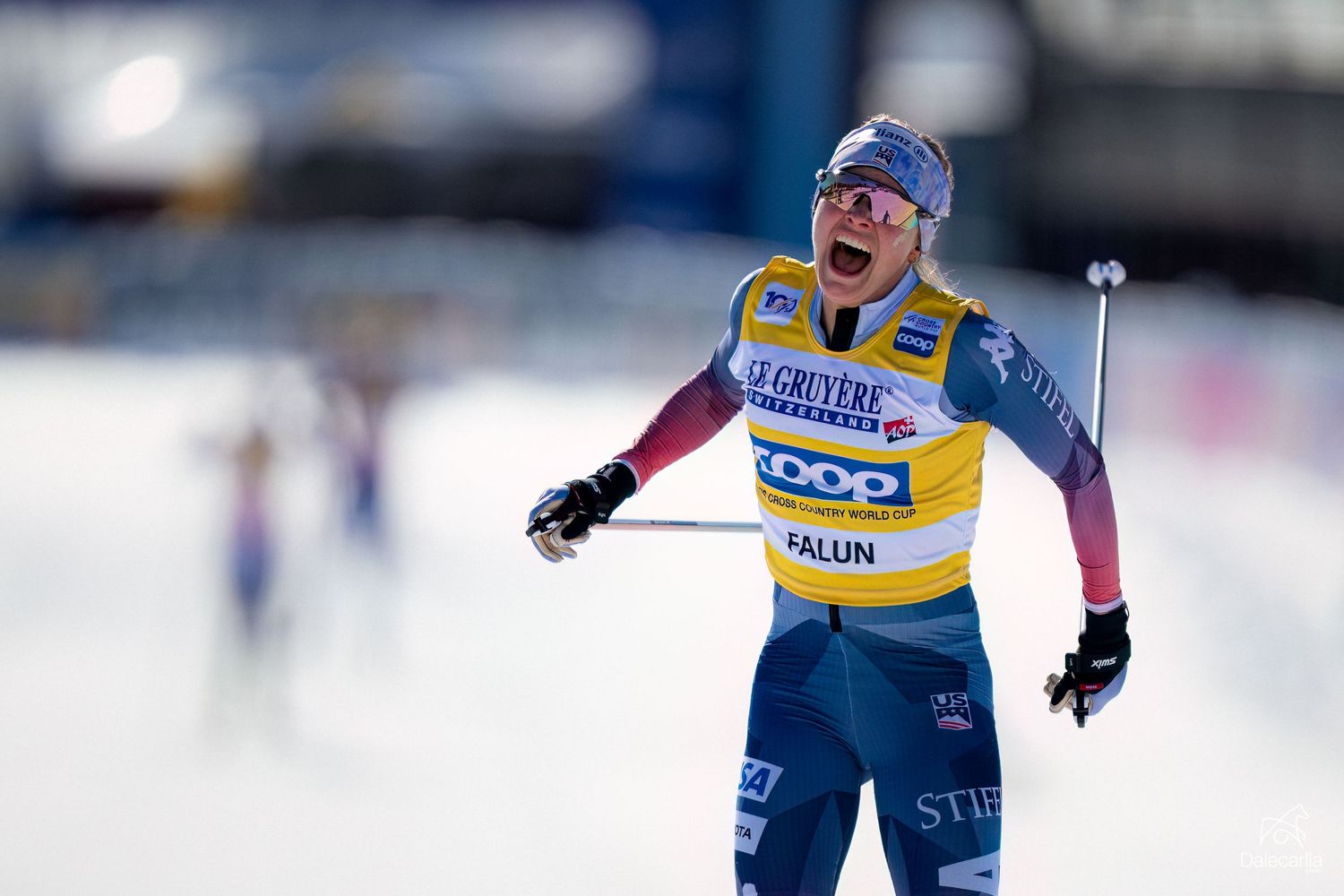 Cross-country skier in blue and yellow racing suit celebrates during competition at Falun Nordic skiing event.