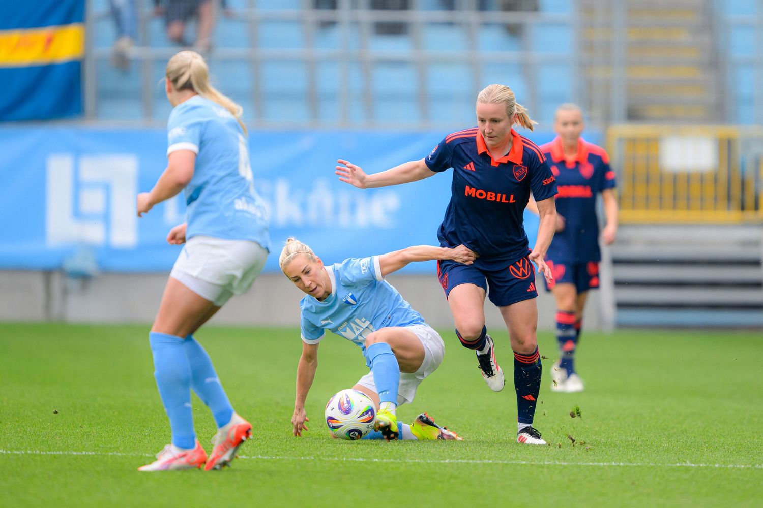 Soccer players battle for possession of the ball during a competitive match on a professional pitch.