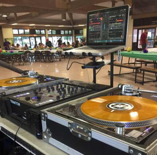 Professional DJ equipment setup with turntables and digital interface in a casual venue.