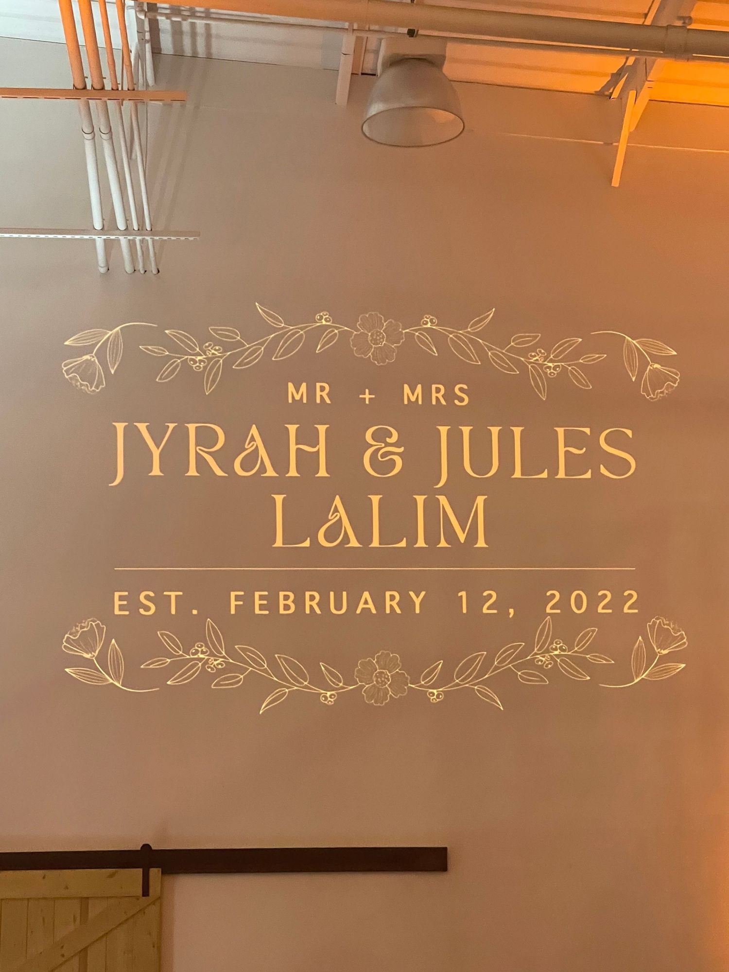 Wedding signage displaying previous clients names with decorative floral elements.