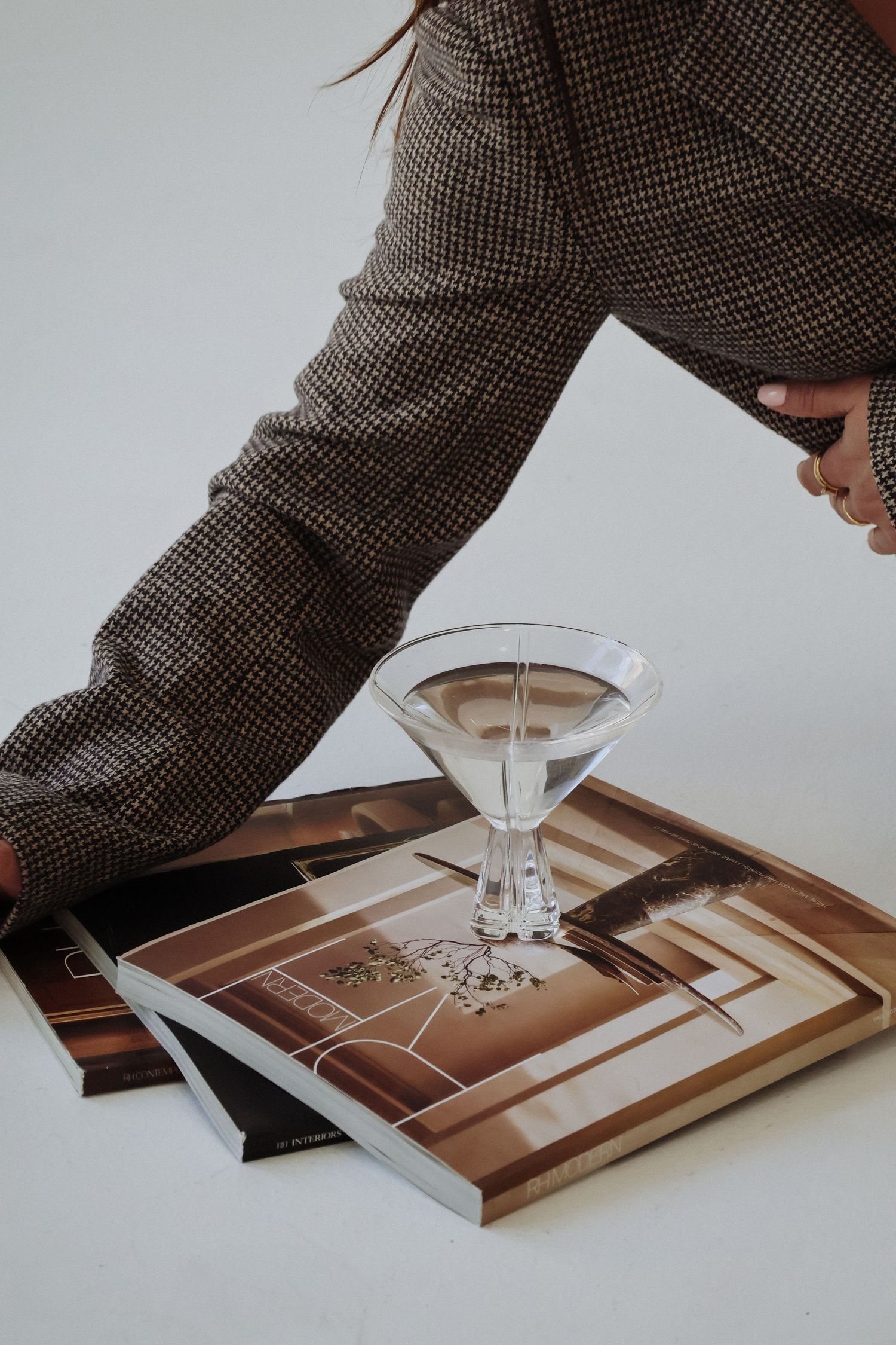 Martini glass being placed on wooden surface in artistic composition.