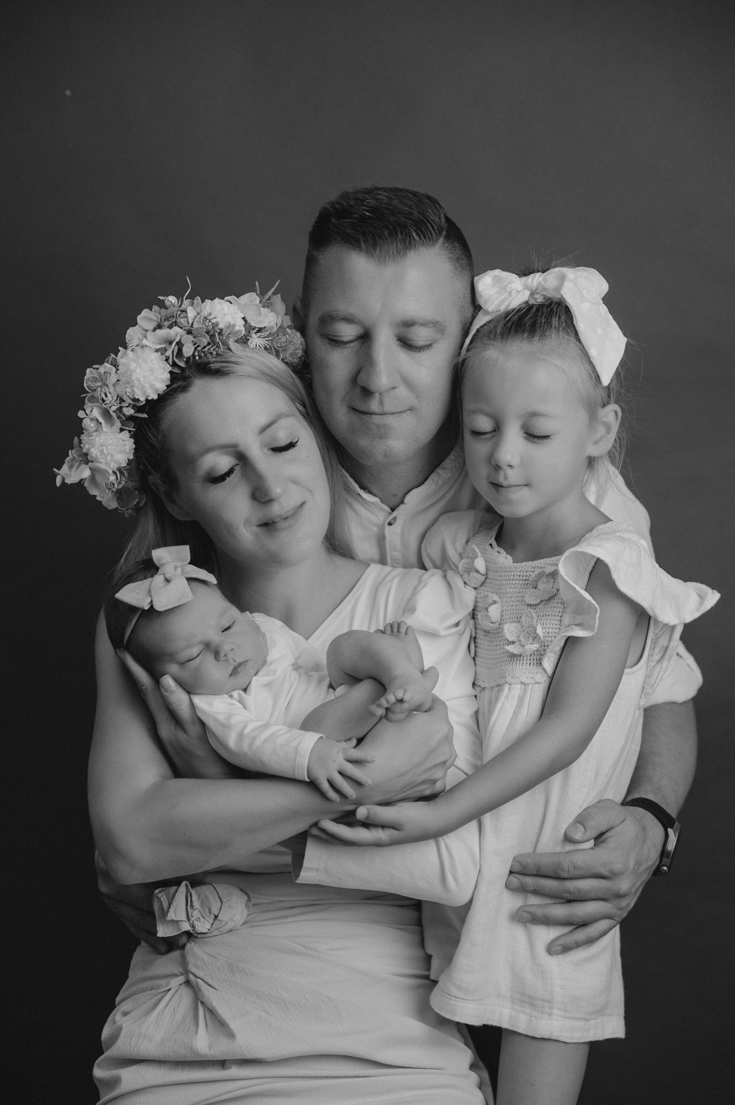 Studio family portrait with mother wearing flower crown holding infant.