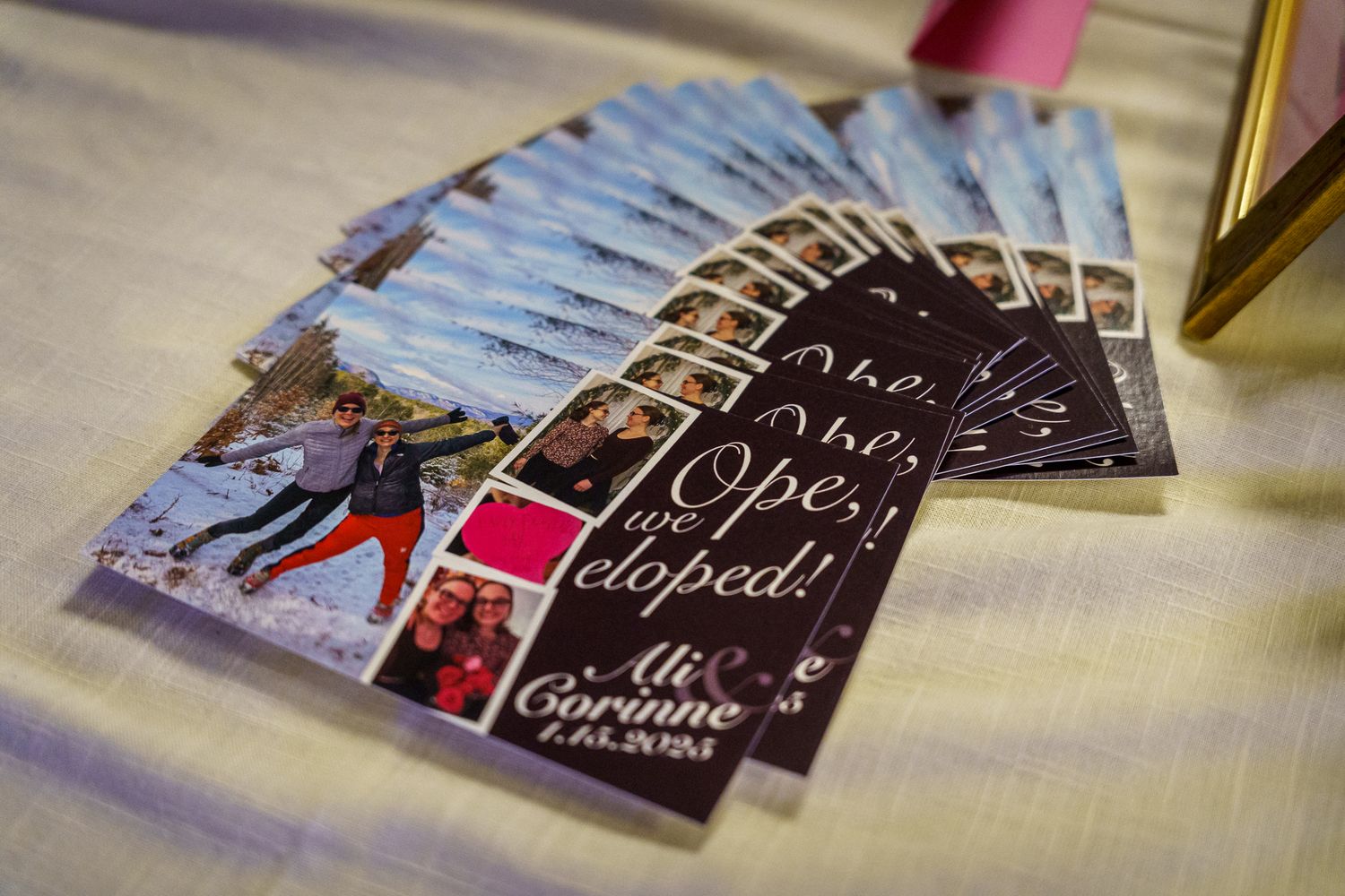 A fan of black printed cards or brochures with handwritten-style text displayed in a spread layout on a light surface.