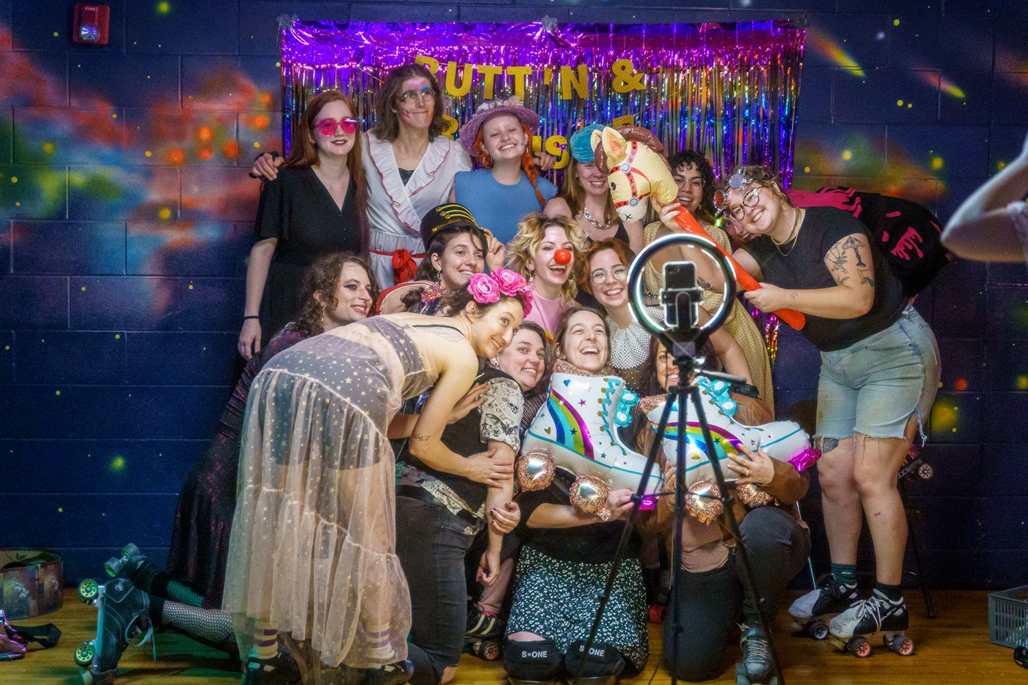 People celebrate and dance together at a nightclub with purple lighting and festive atmosphere.