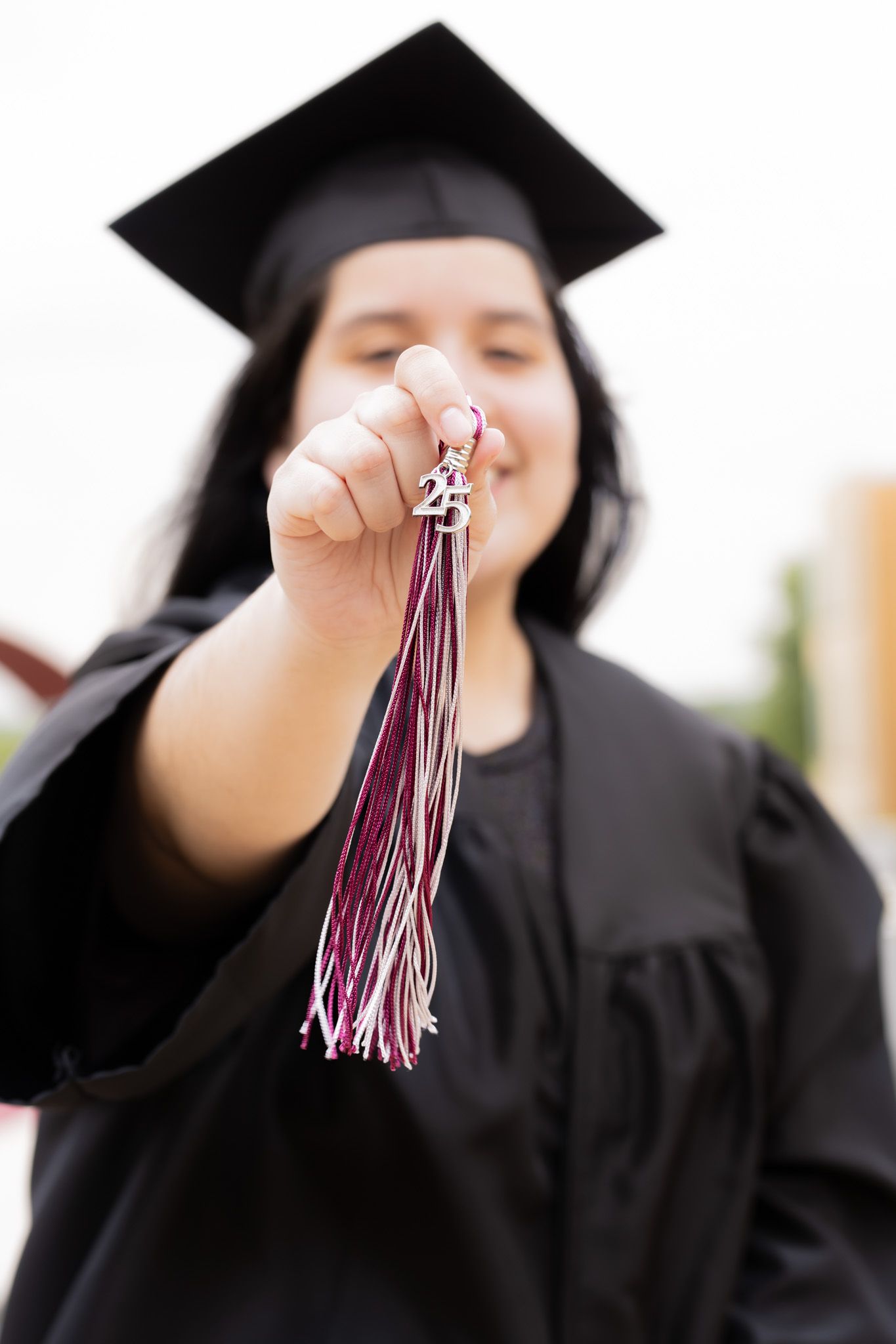 Graduation tassel in maroon and white colors shown in close up motion shots.