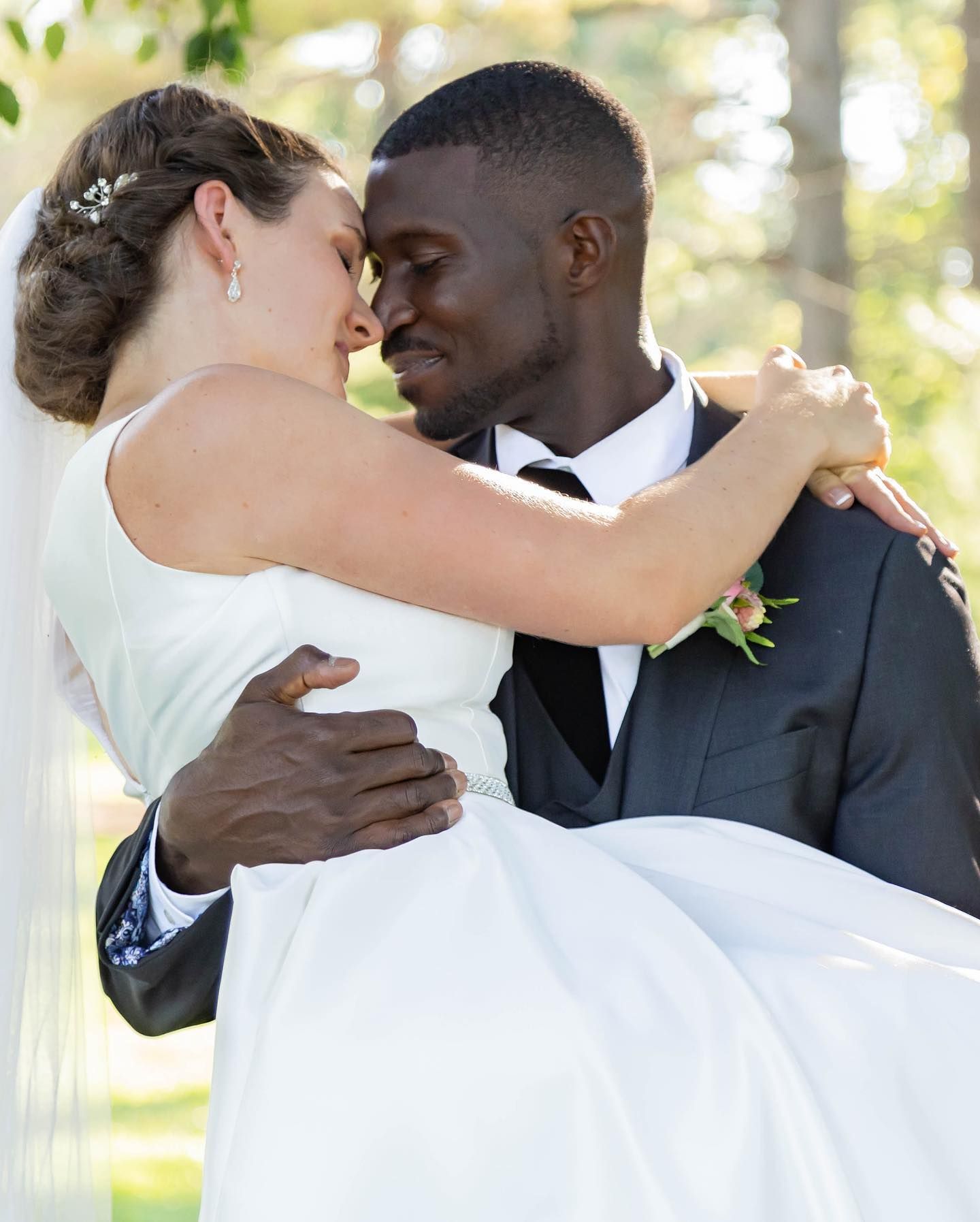 Joyful wedding moment captured outdoors with couple embracing.