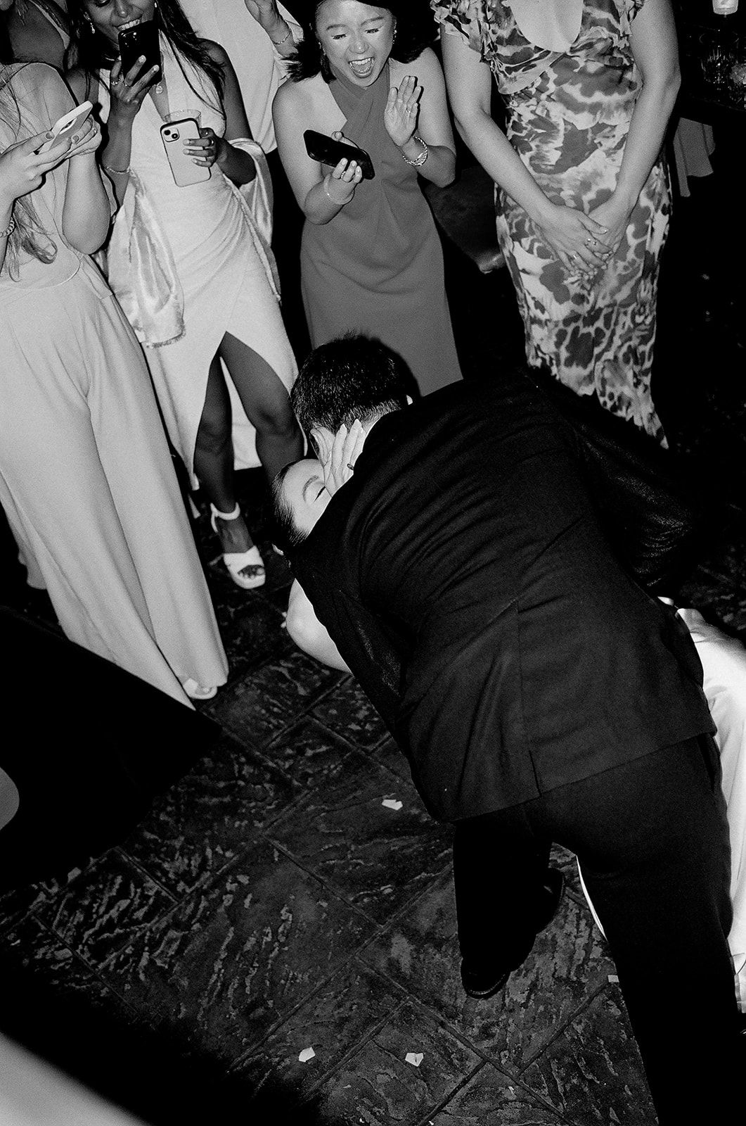 A black and white photo captures people dancing and enjoying themselves at what appears to be a party or celebration.