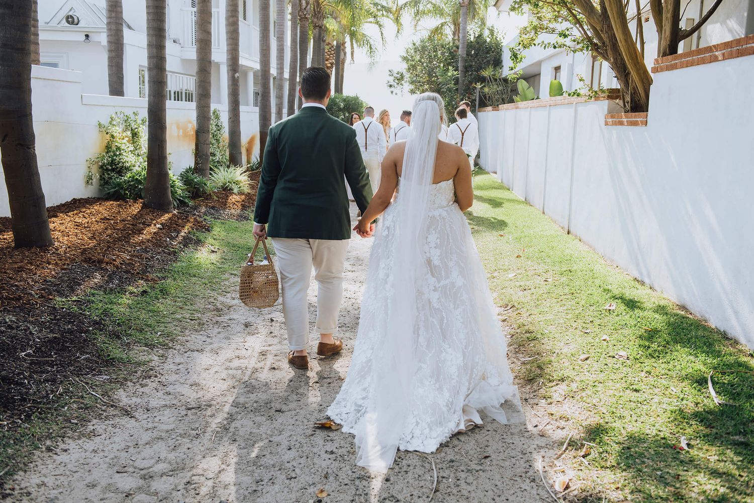 Bride and groom walking towards the beach holding a picnic basket in Palm Beach - Zara King Photography, Sydney Australia