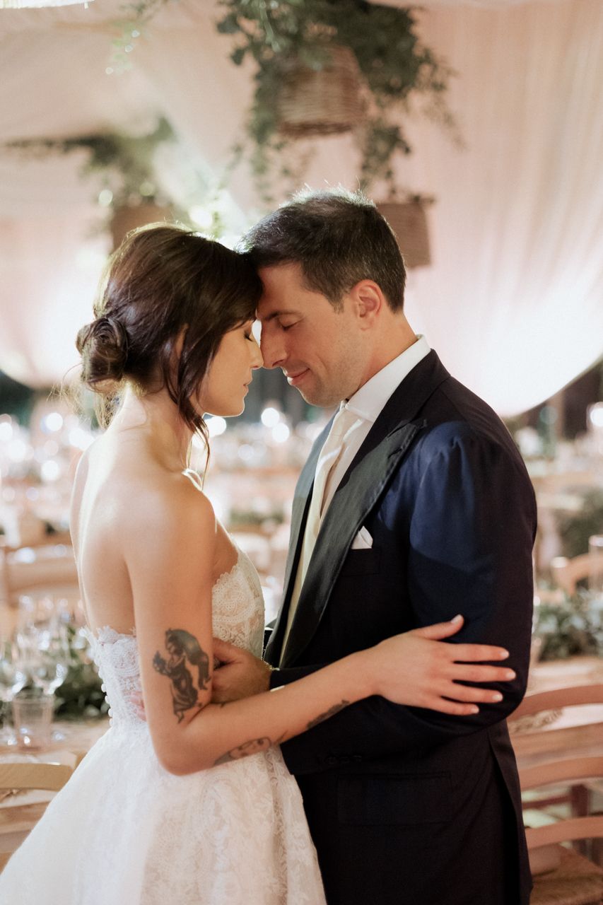 Romantic moment captured between bride and groom at wedding reception.