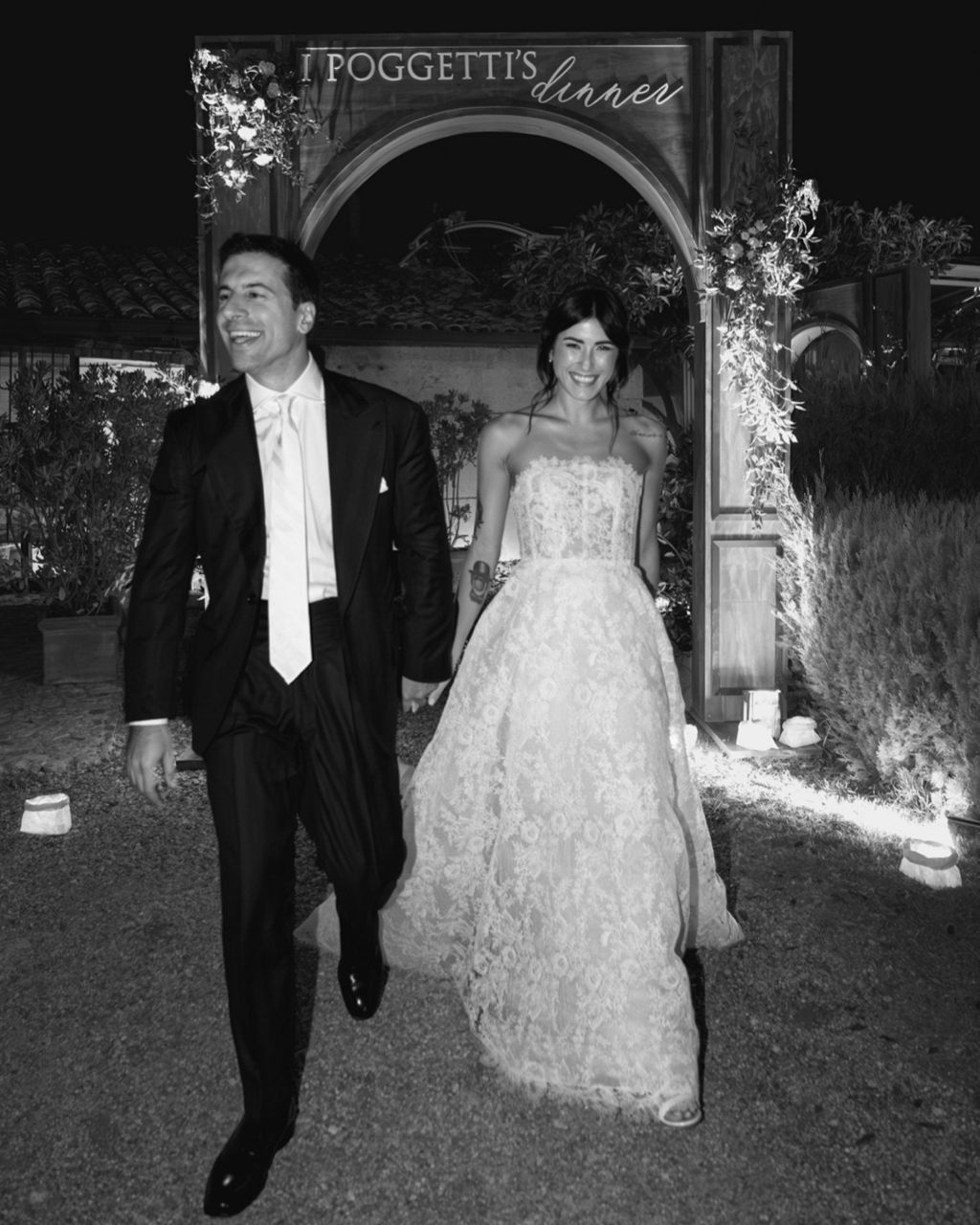 Newlyweds exit through an illuminated archway at Froggett's during their wedding celebration.