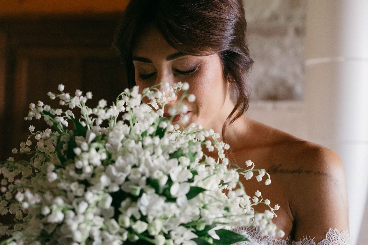 An artistic bridal portrait showcasing a stunning bouquet of white flowers and lace detailing.