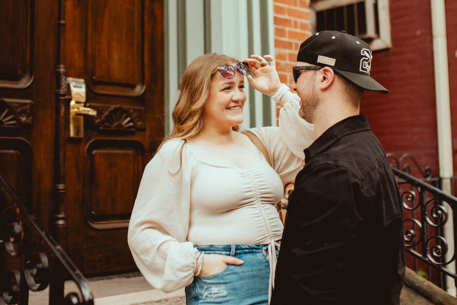 Couple sharing a playful moment on urban brick steps.