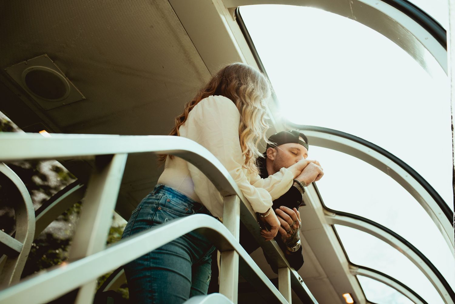 A stylish couple posing in the observation car of a vintage train.