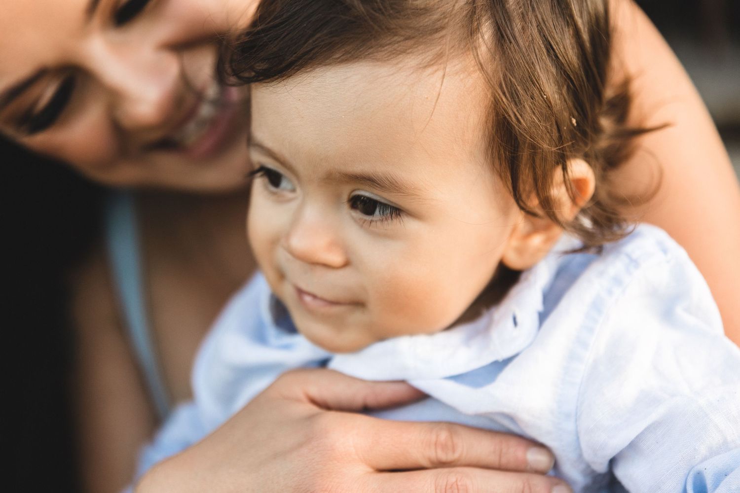 Close-up tender moment between parent and child in soft natural light. Sandon Point