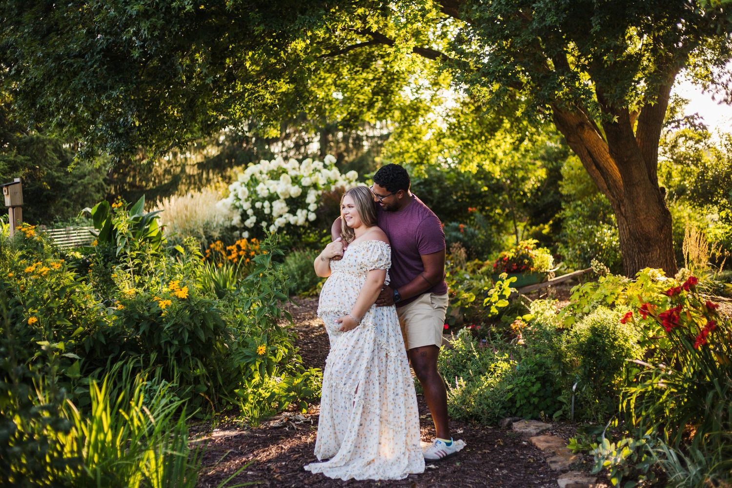 Dad gently holding baby bump while mom looks down with soft smile – Springfield Missouri maternity photography