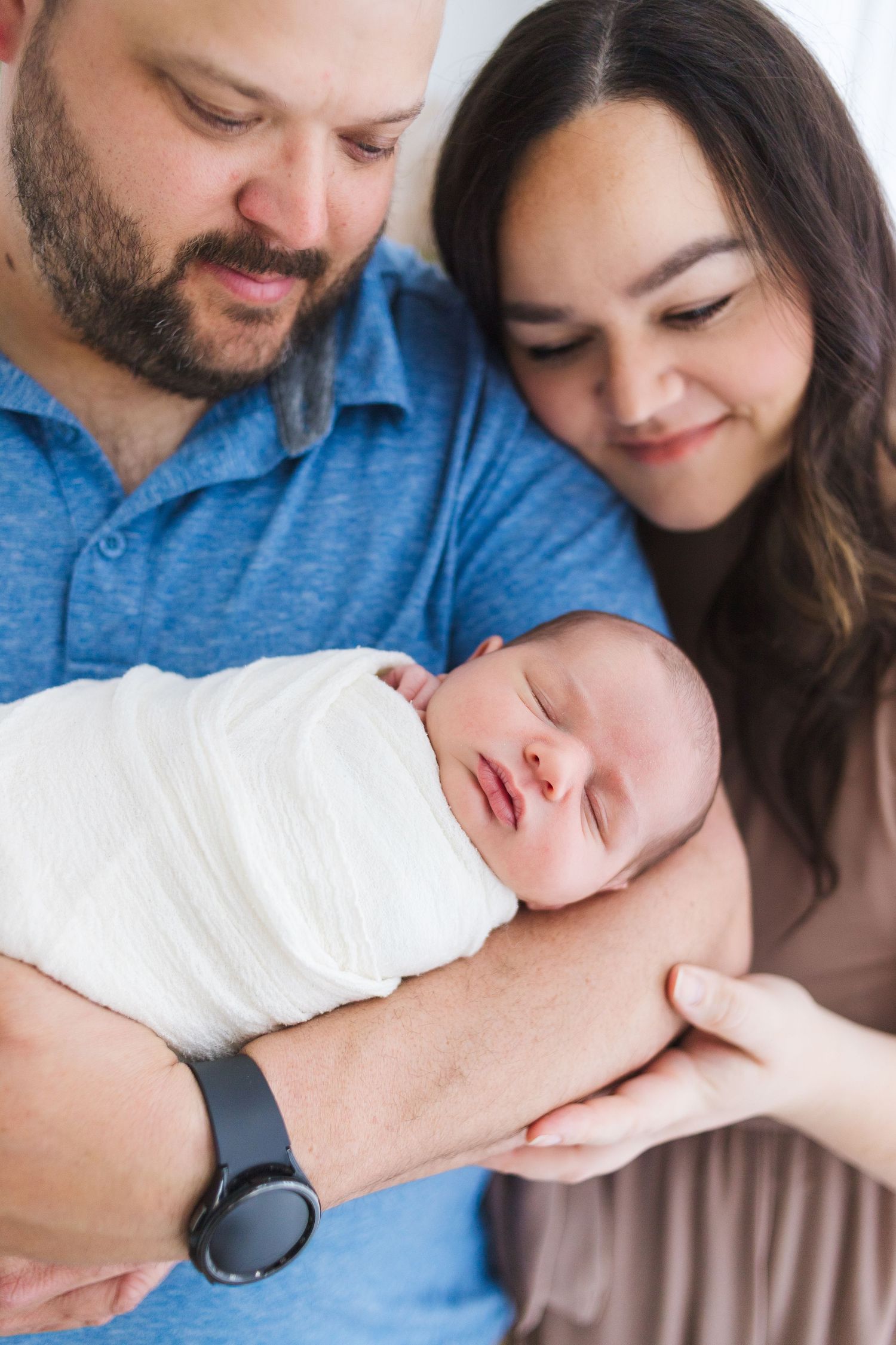 Mom and dad holding newborn during soft studio session at Share 417 – Springfield MO newborn photographer