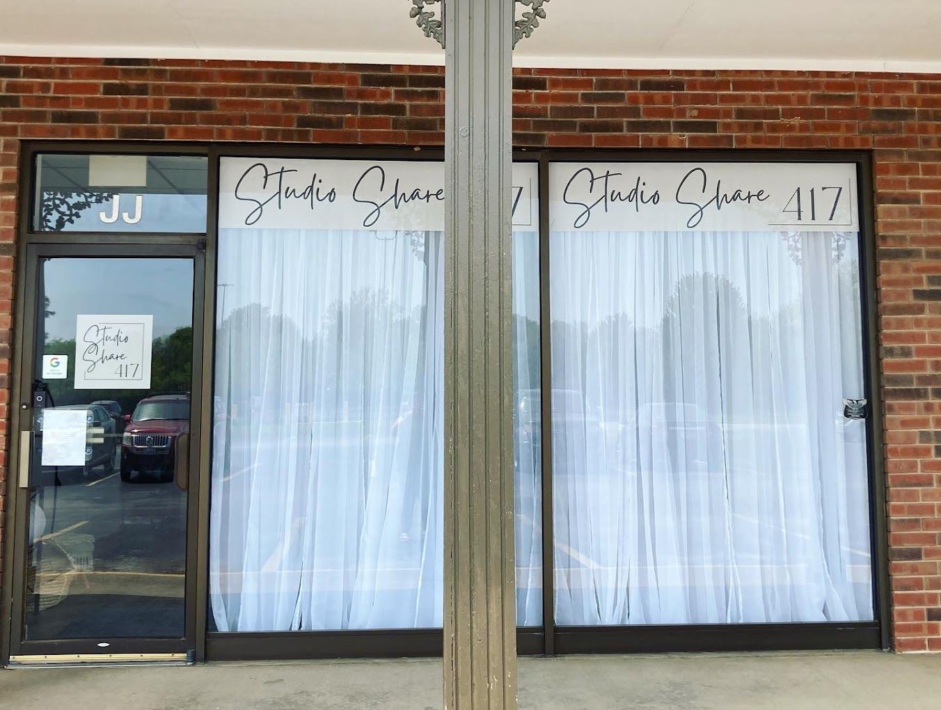 Storefront with 'Amber Dawn' signage and white curtained windows in brick building.