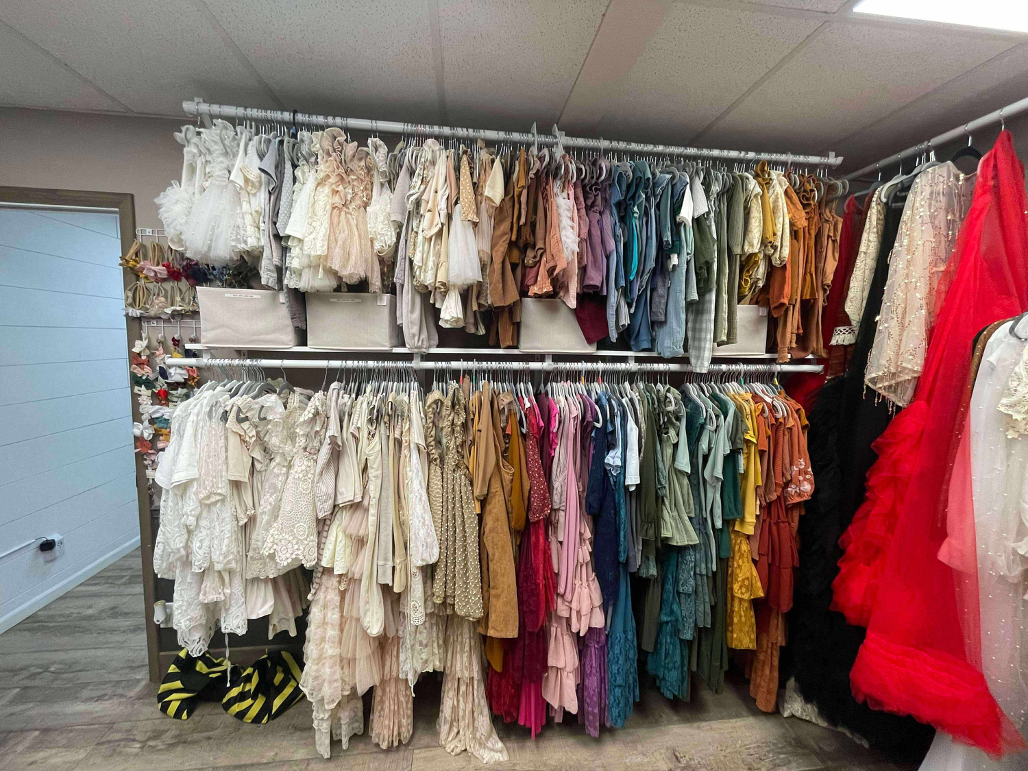 Clothing retail space with racks of hanging garments in various colors and styles.