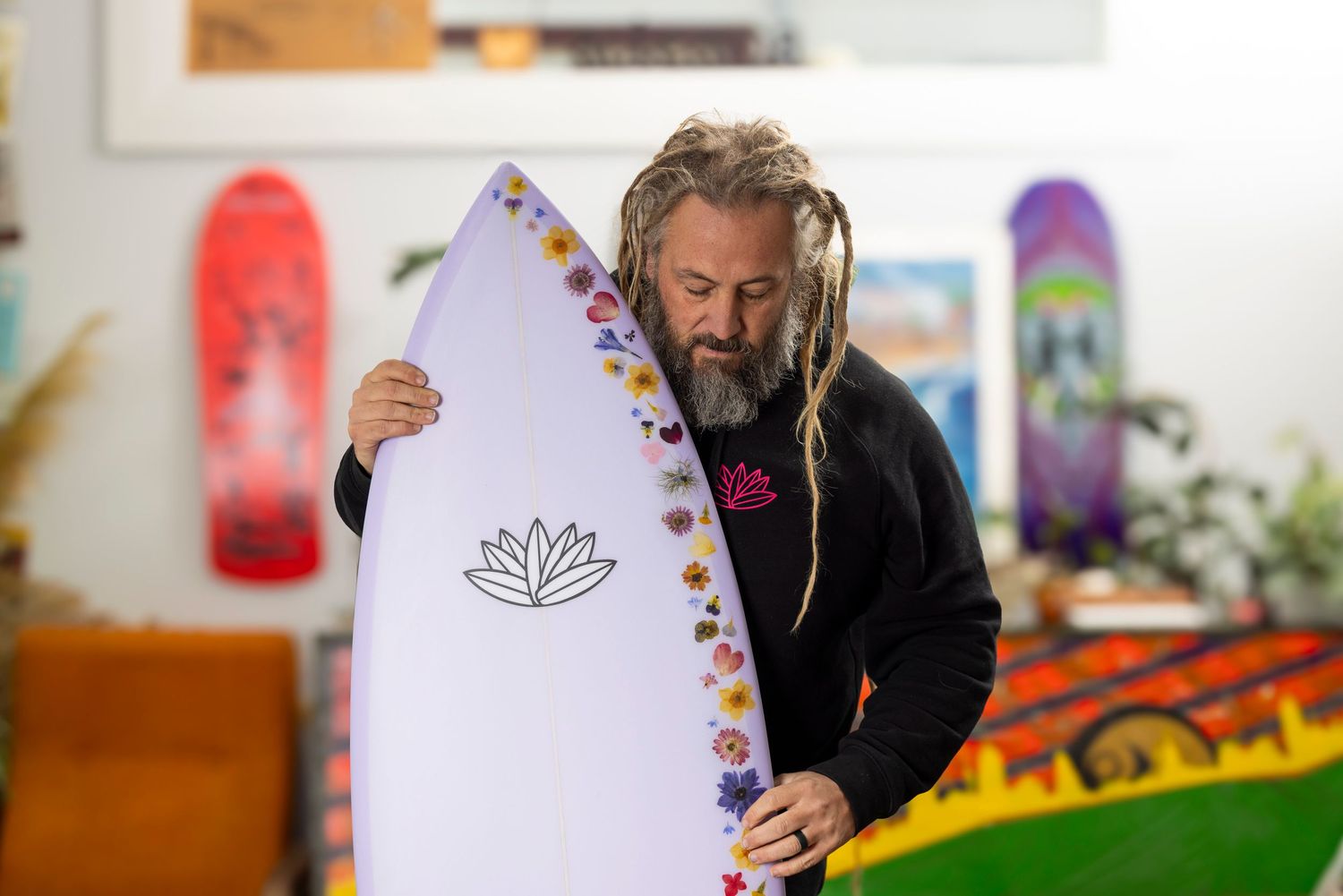 Collection of surfboards being examined in bright indoor setting.