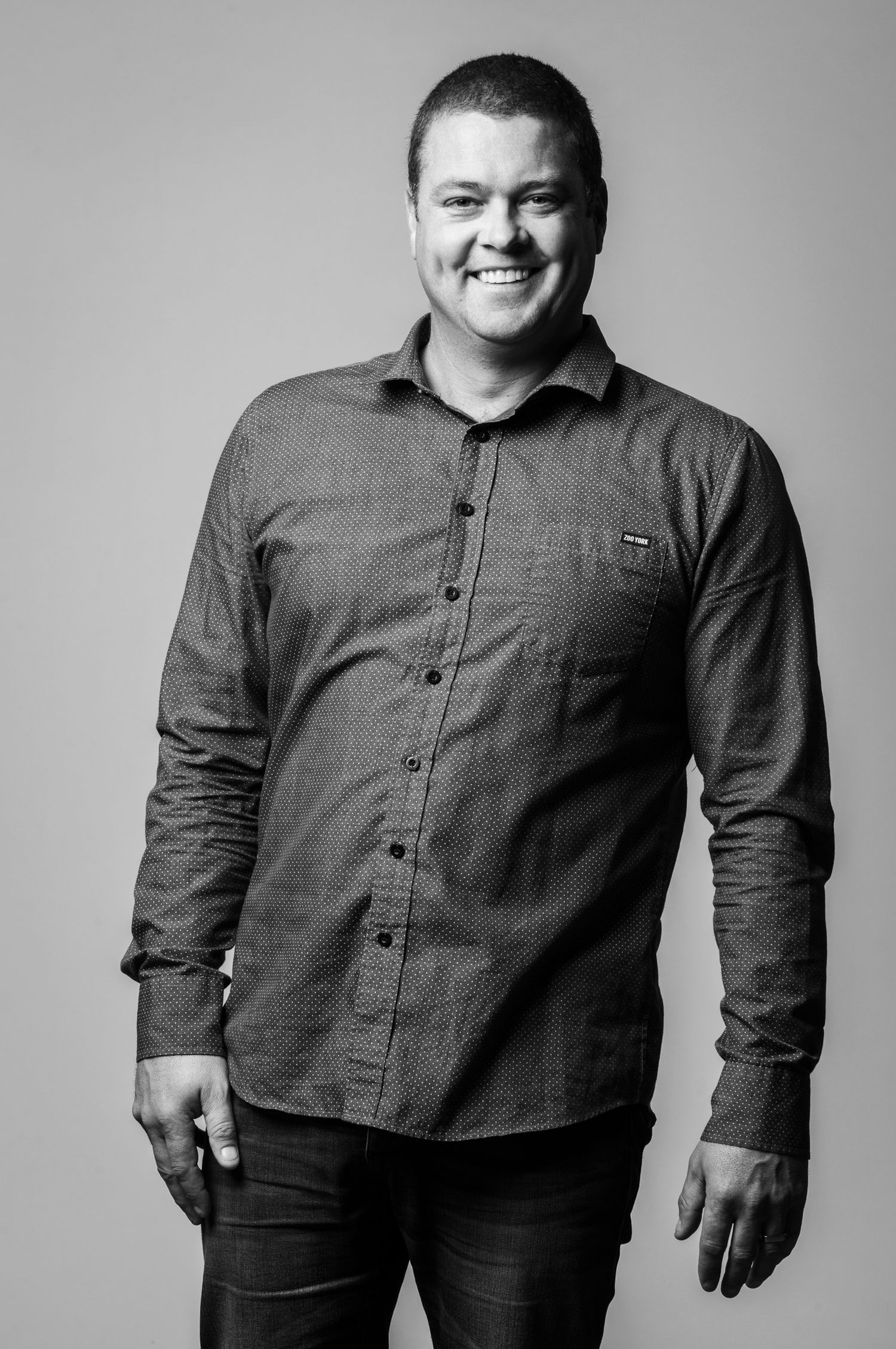 Black and white portrait series showing person in gray button-down shirt against neutral backdrop.