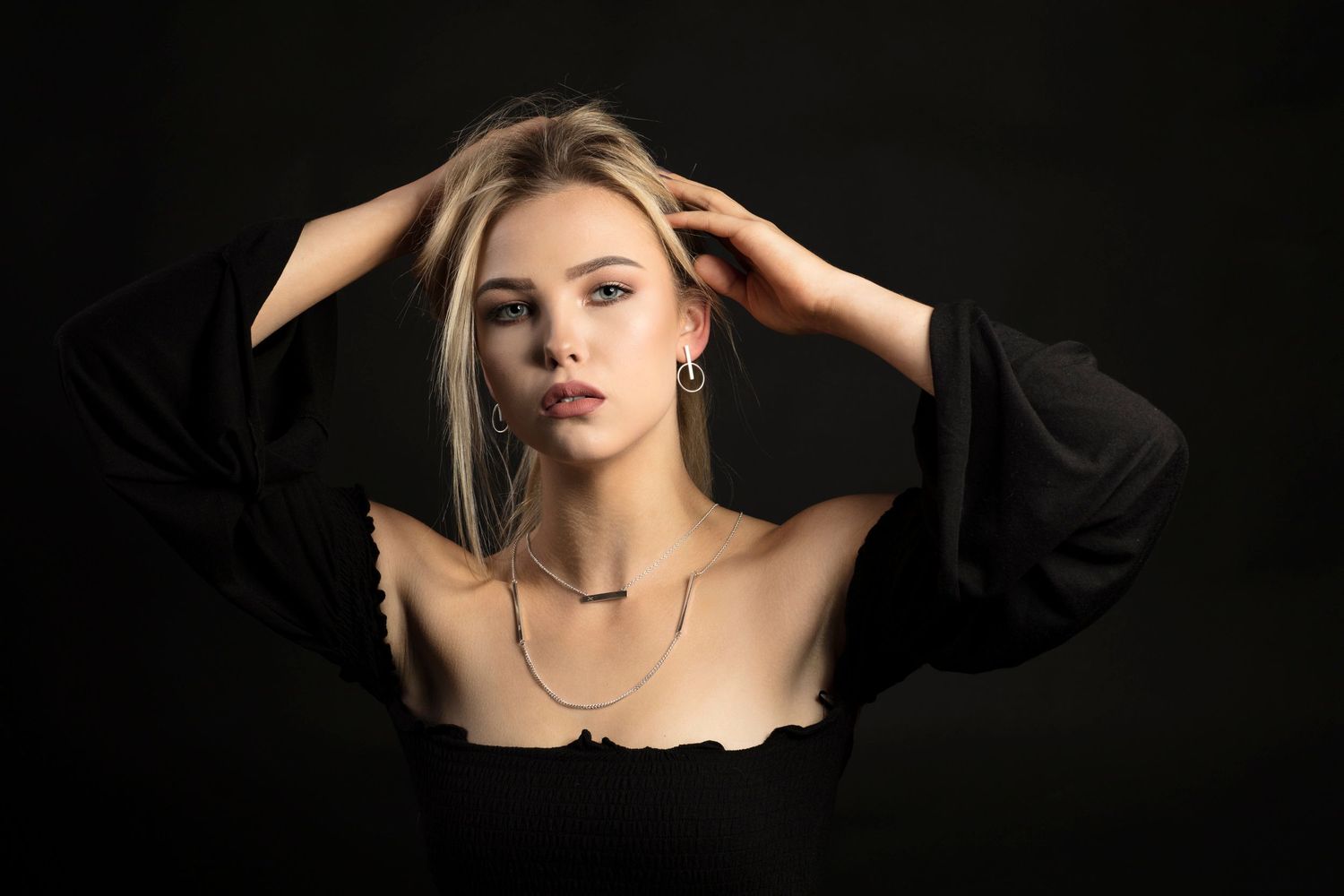 Dramatic portrait series against black background with moody lighting and elegant styling.