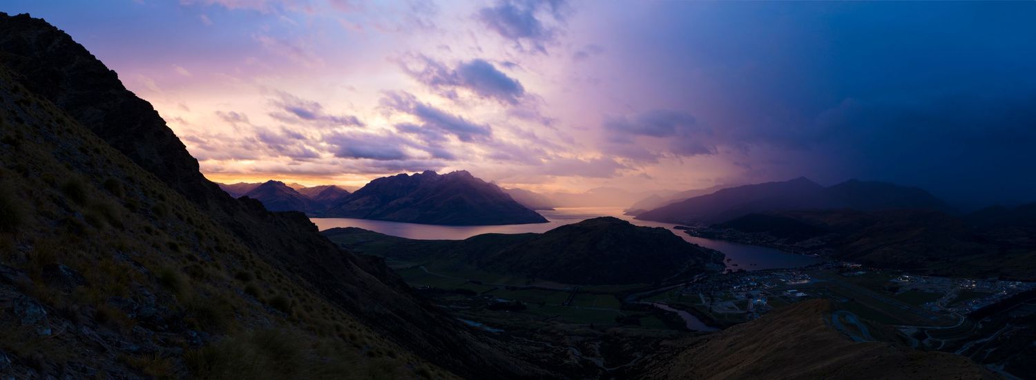 Dramatic mountain landscape at sunset with purple and blue sky panorama.