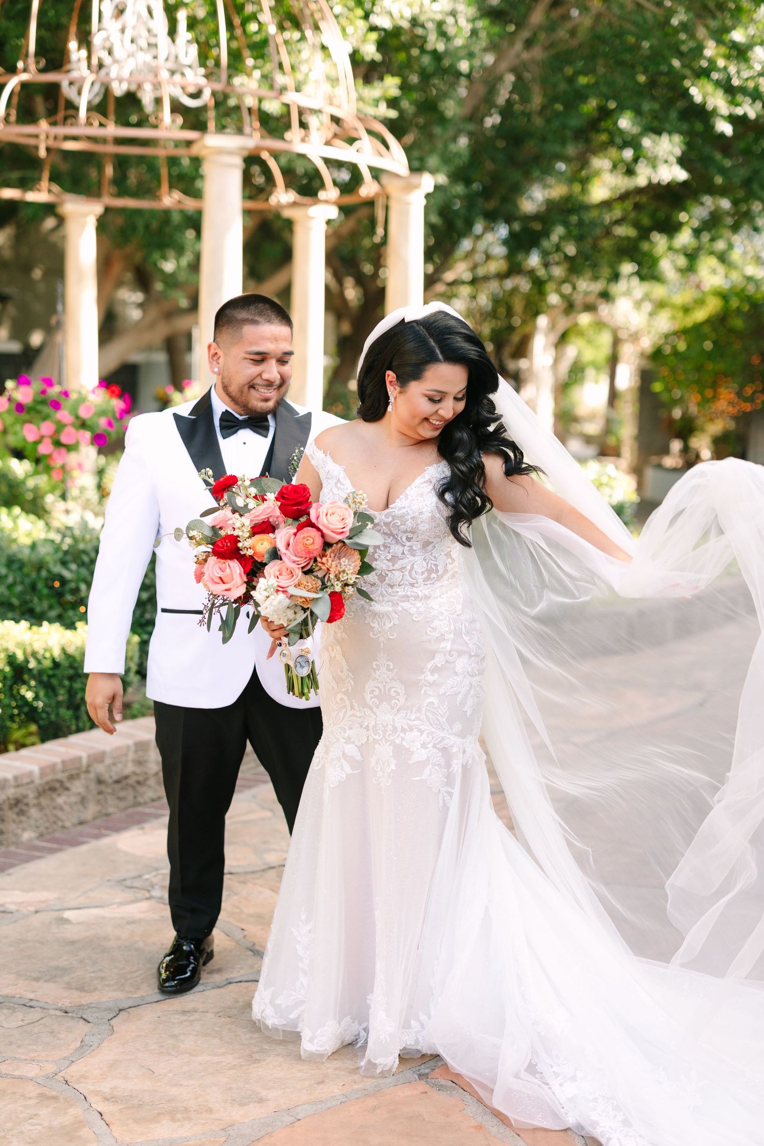 A joyful couple walking under a garden gazebo on their wedding day. Molly McPhoto