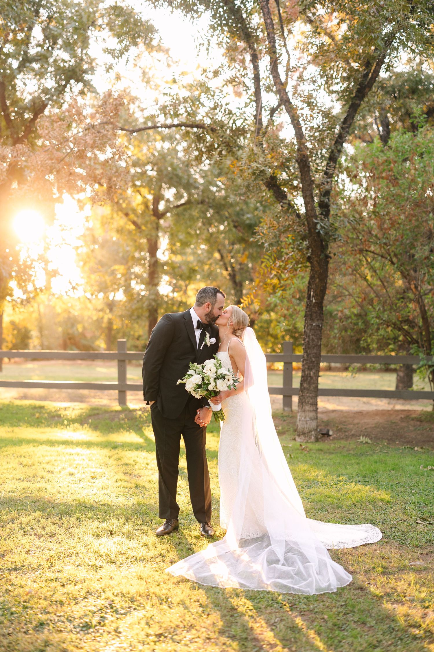 Wedding couple shares intimate poses against a sunlit autumn backdrop in a park.