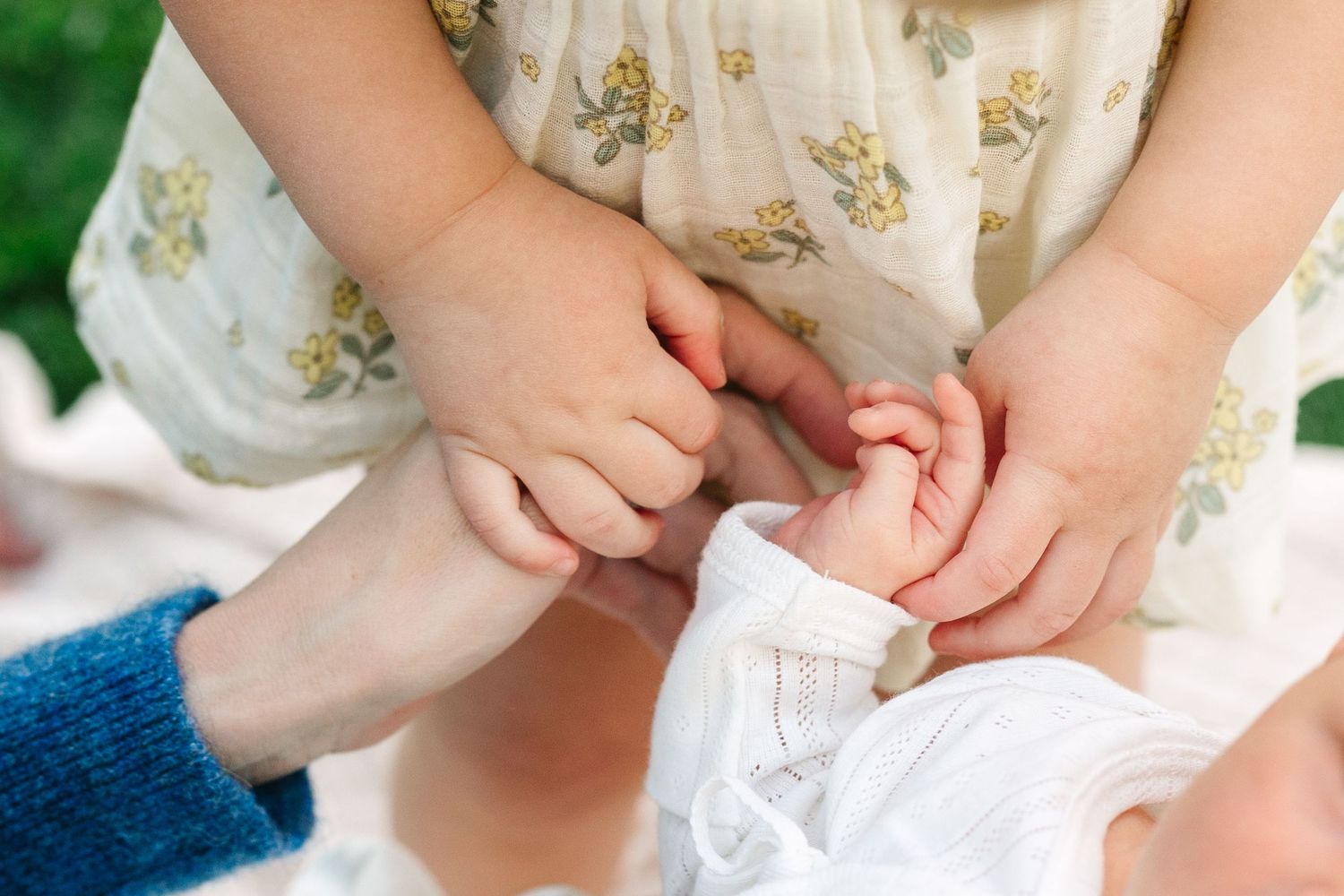 Close-up series showing hands gently holding and examining a tiny newborn baby's fingers and toes.