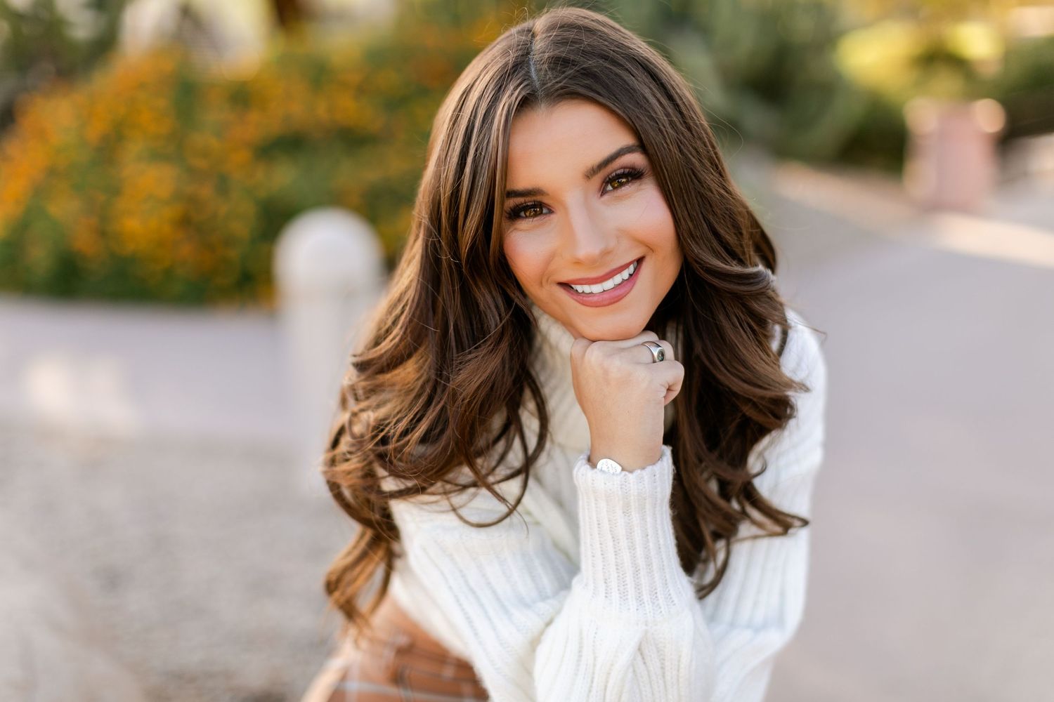 Four outdoor portrait photos of someone in a white sweater posing with autumn scenery in the background.