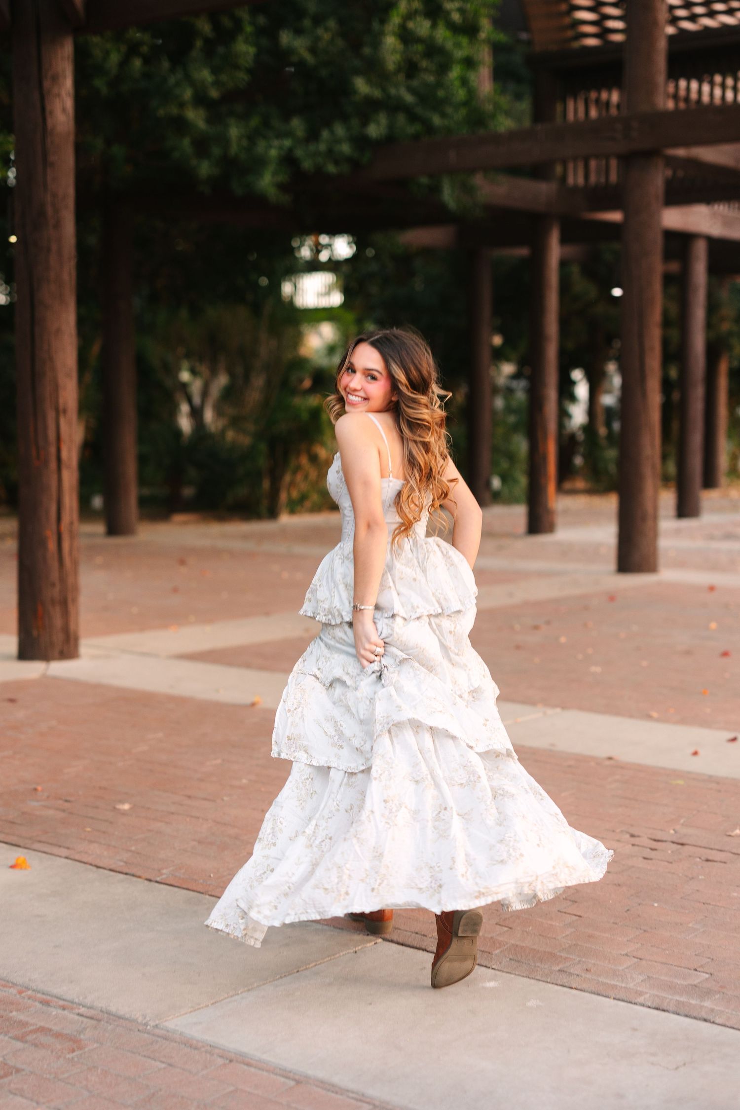 A series of photos shows a dancer in a white dress twirling with flowing movement across a brick courtyard.