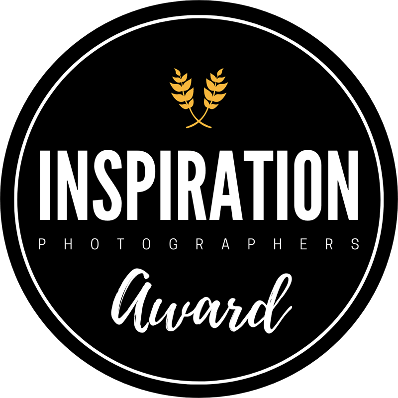 A circular black and gold logo for Inspiration Photographers Award featuring wheat stalks as a design element.