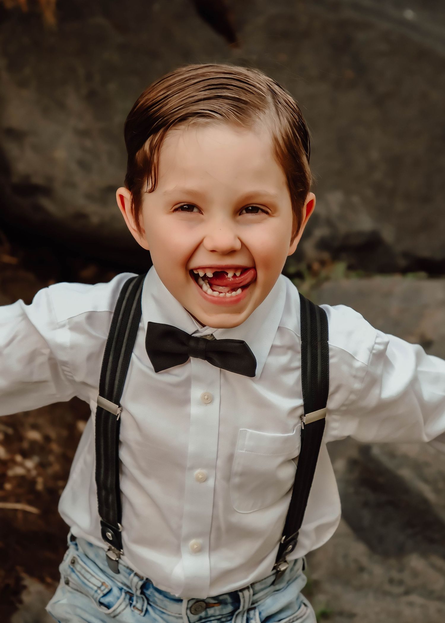 A photo of a young boy sticking his tongue out to the side and dressed nicely for a family photoshoot with Life Well Spent Photography