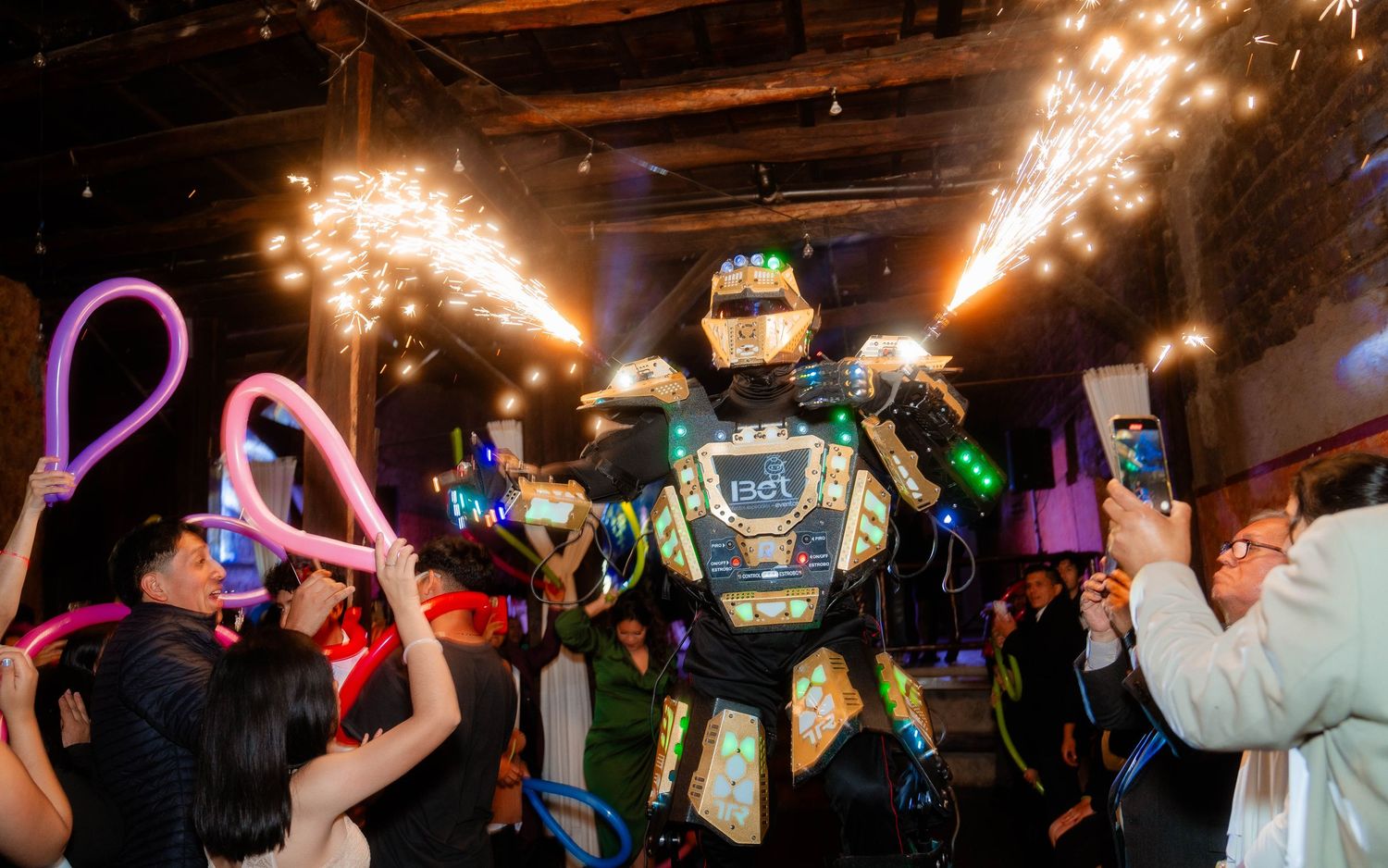Lively dance party scene with sparklers and uplighting creating festive atmosphere.