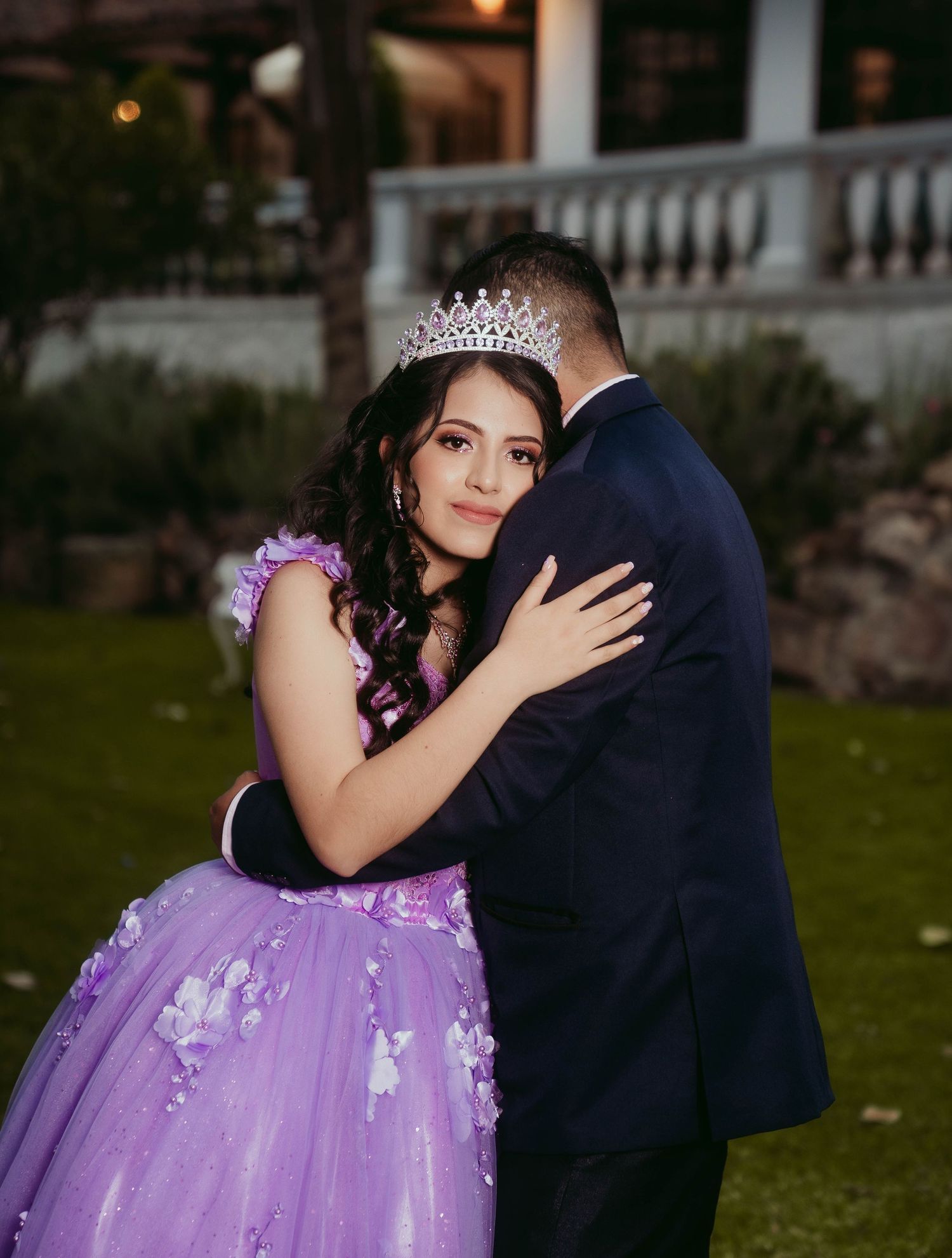 Formal dance in purple ball gown at outdoor evening celebration.