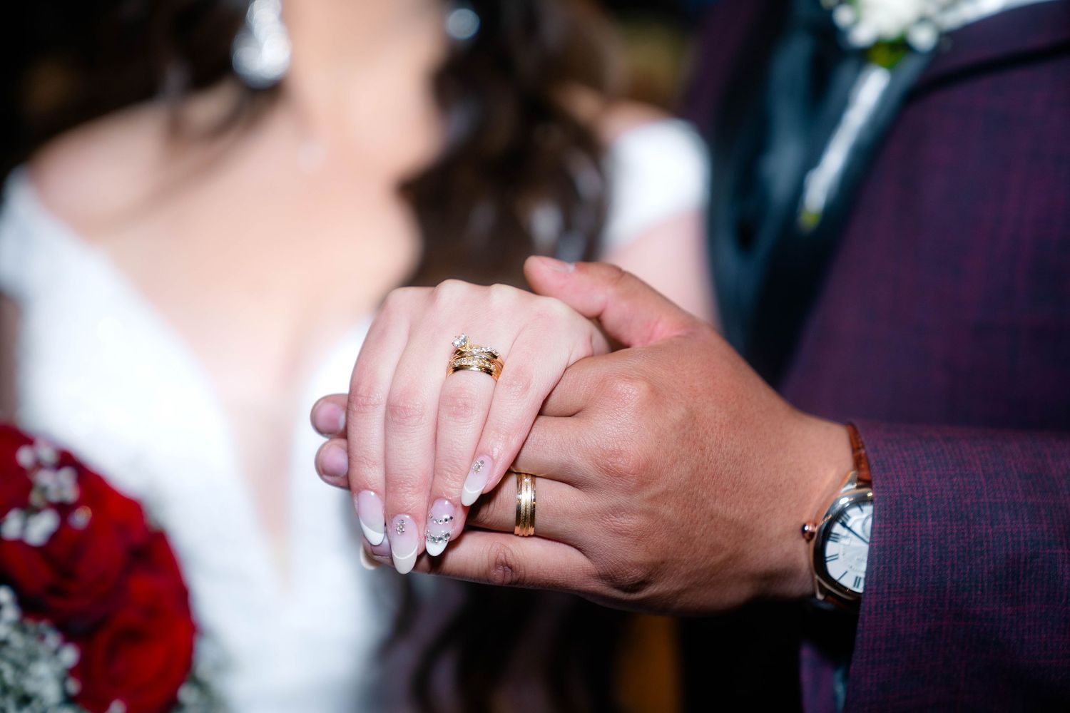 Close-up of hands showing wedding rings during ceremony.