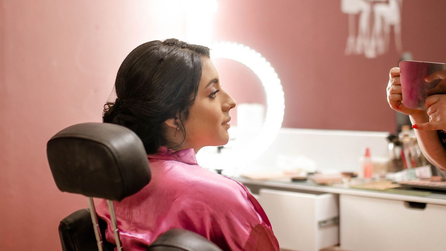 Side profile of person reclining in dental chair wearing pink.