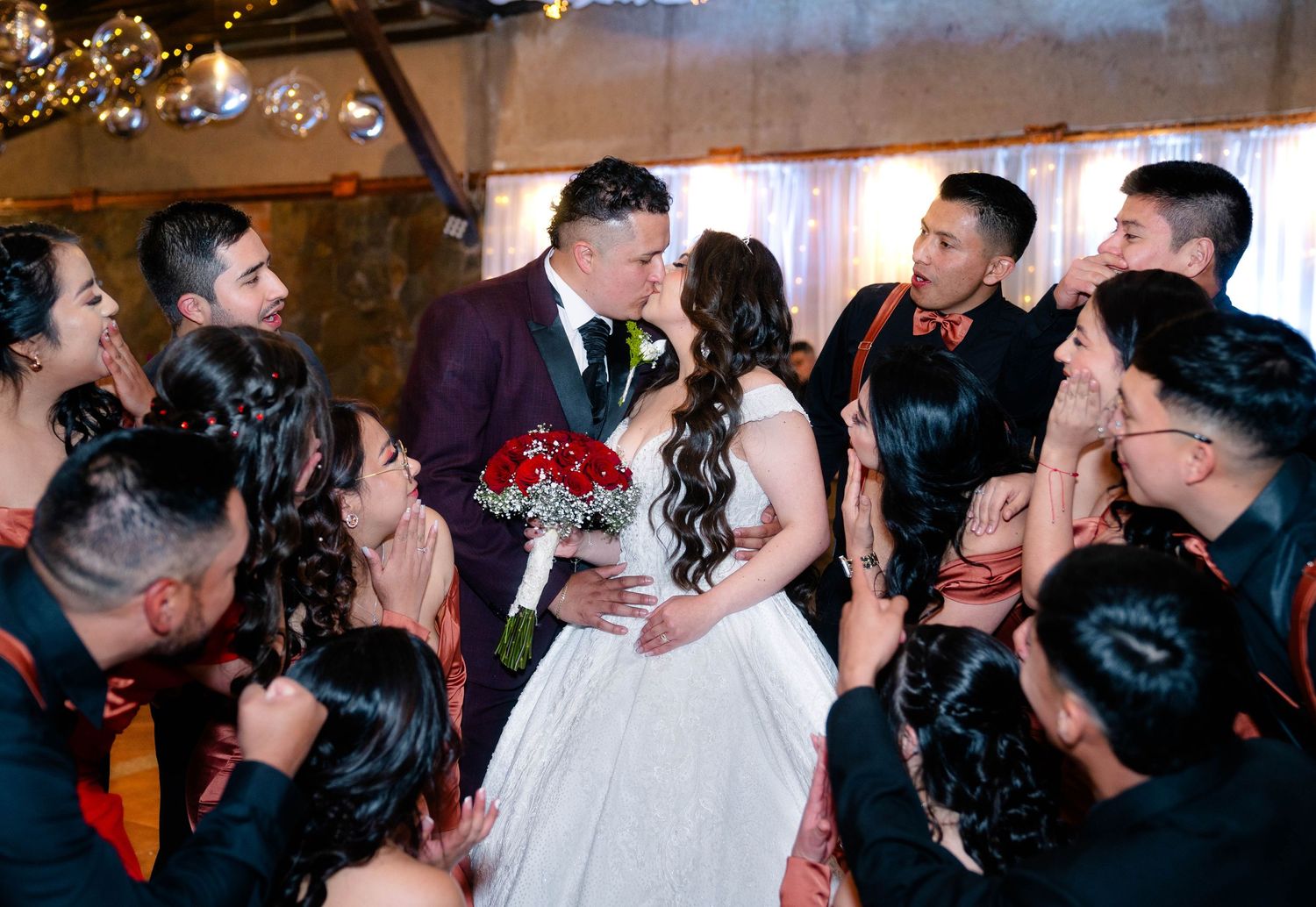 A newlywed couple surrounded by celebrating guests at their wedding reception.