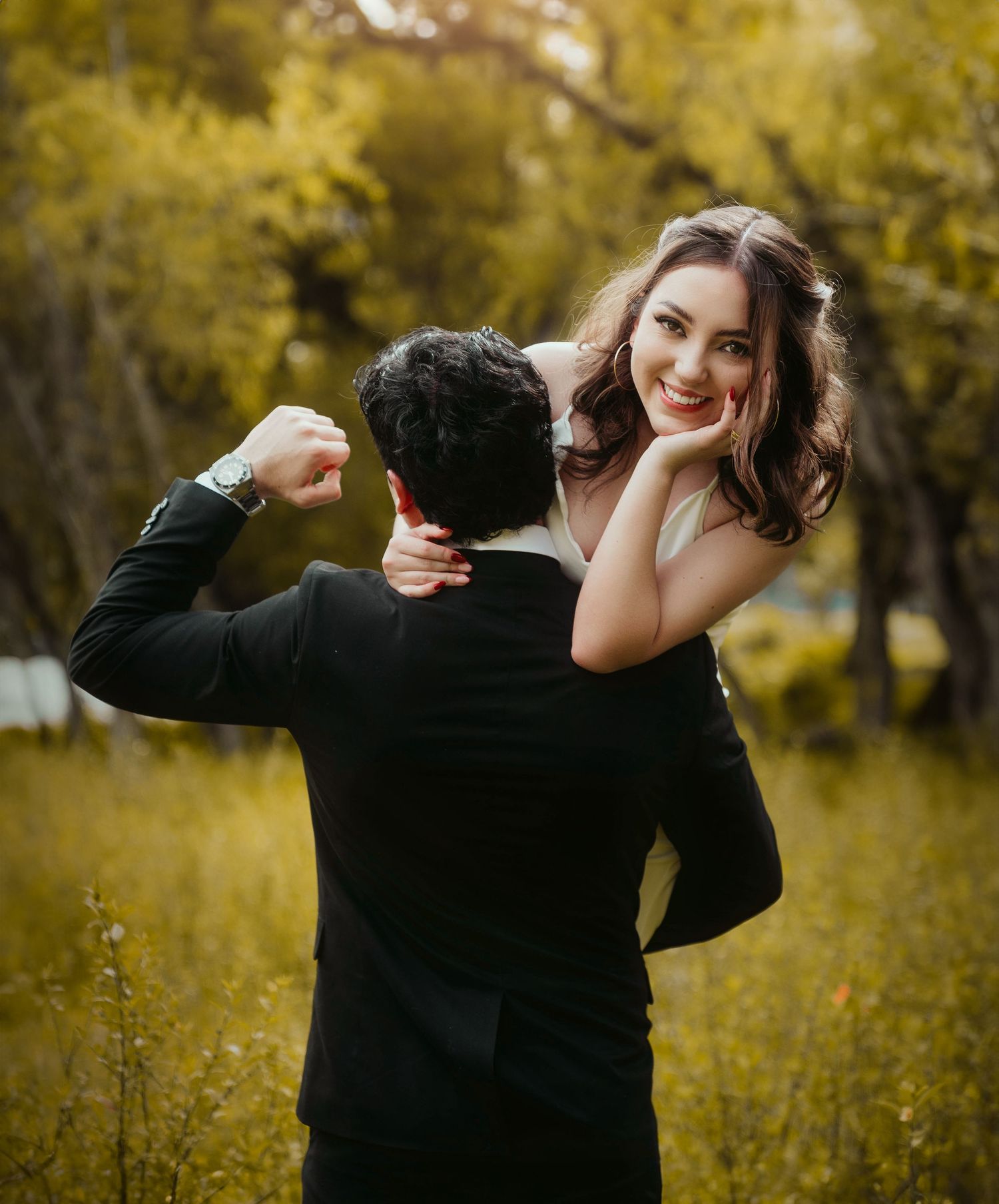 Romantic autumn engagement photo with couple embracing in golden foliage.