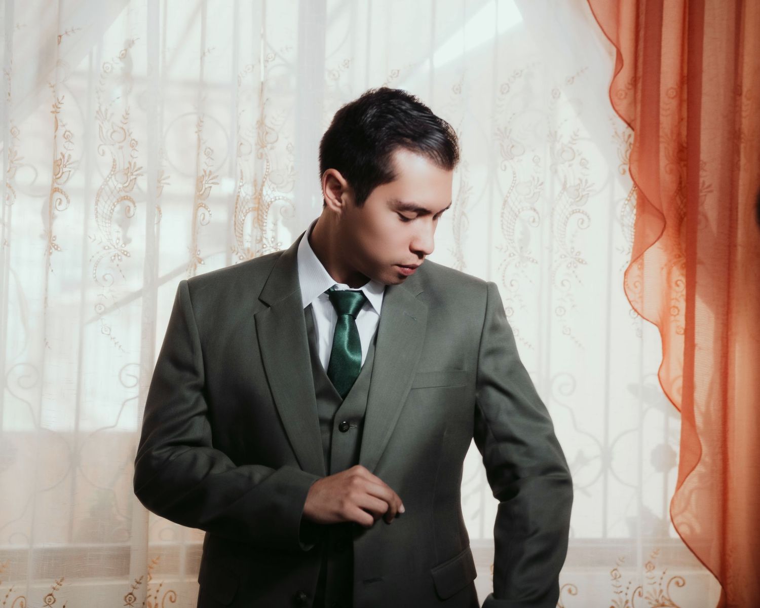 A person in a dark suit and tie sits at a desk, shown in a sequence from different angles.