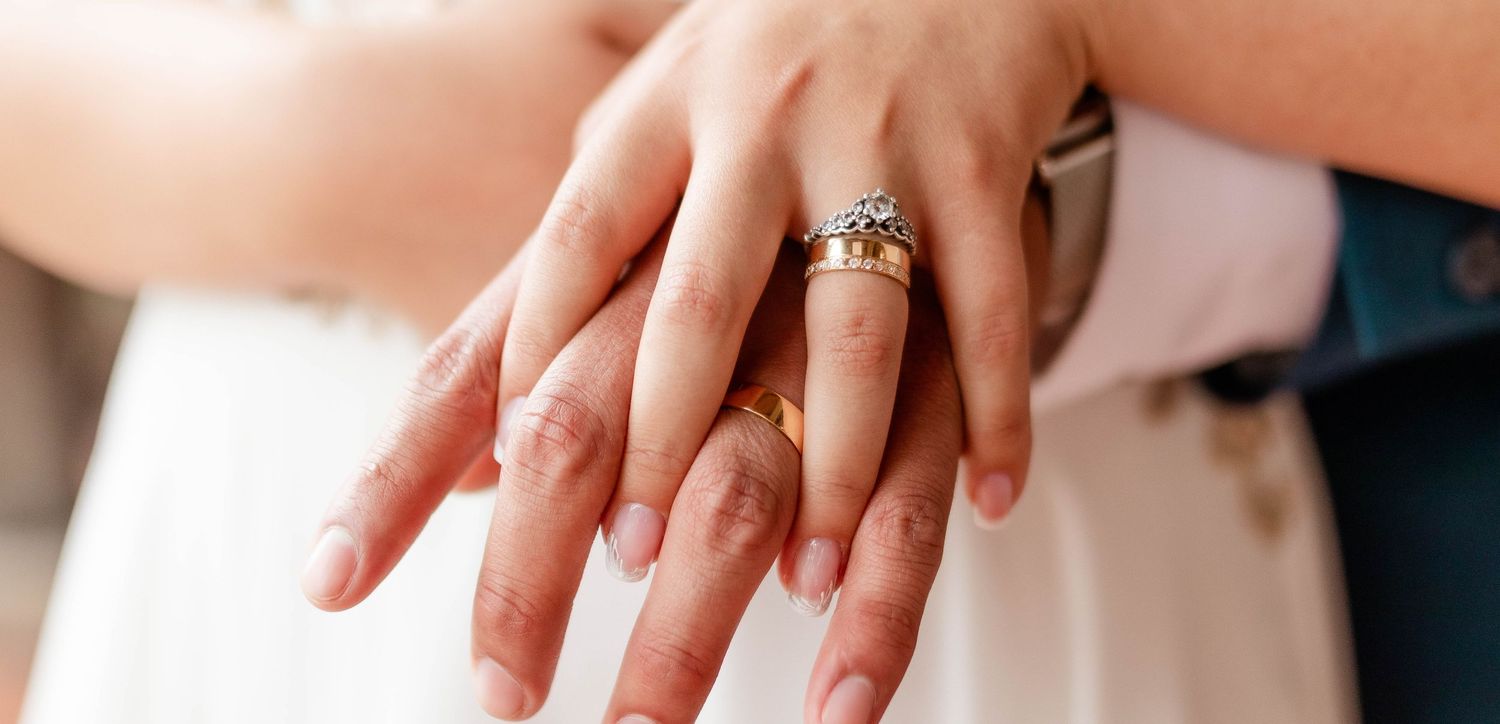 Elegant engagement ring displayed on manicured hand with natural lighting.