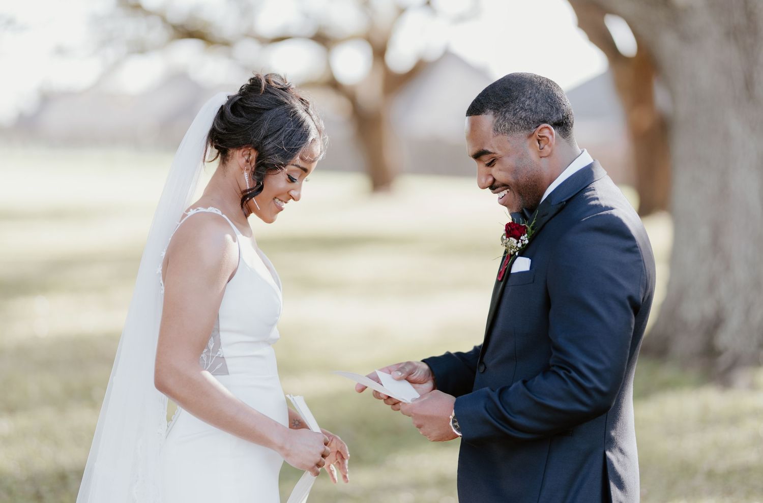 A bride and groom share an intimate moment during their outdoor wedding ceremony on a sunny day.