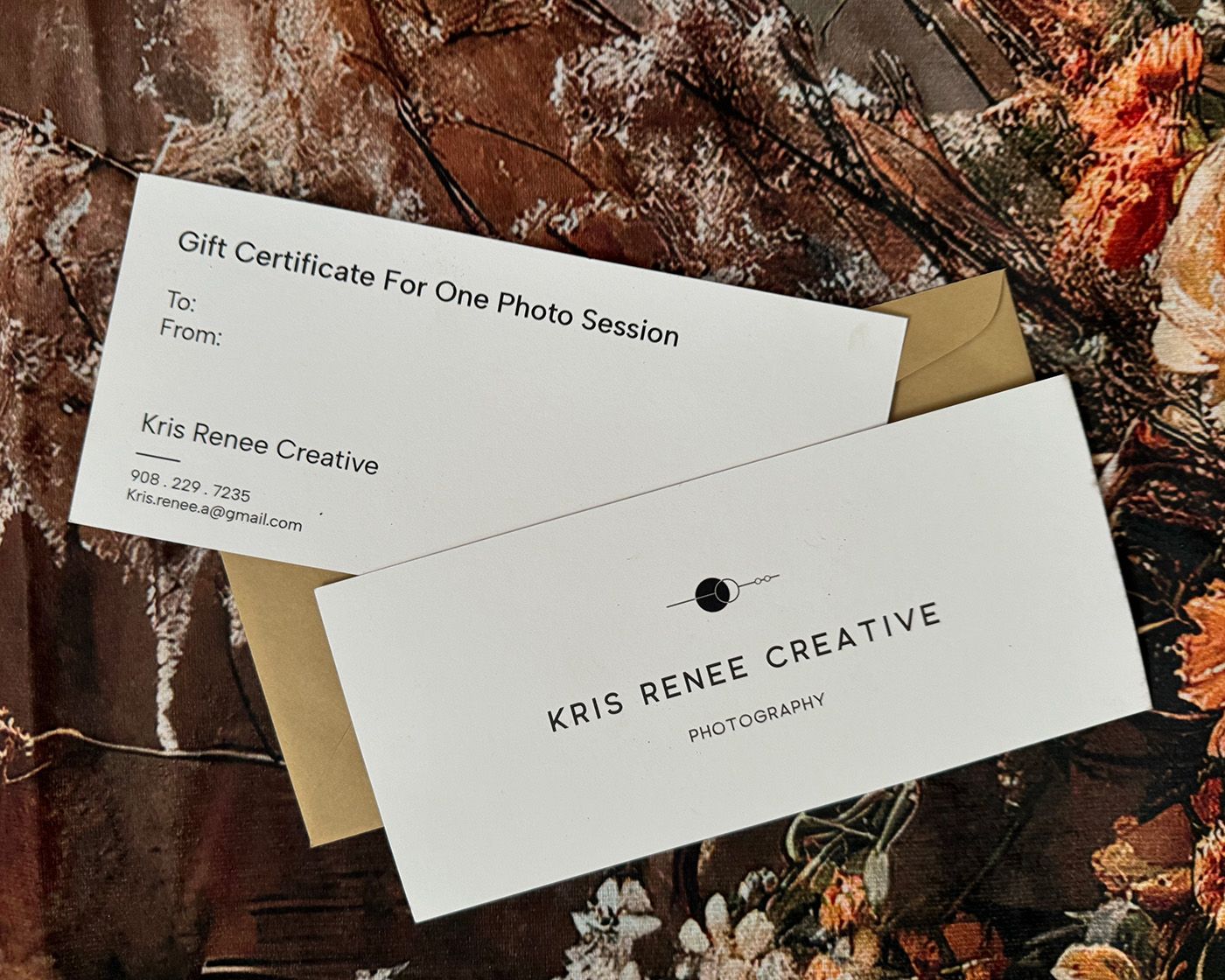 Photography gift certificate and business cards displayed on floral backdrop with gold accents.