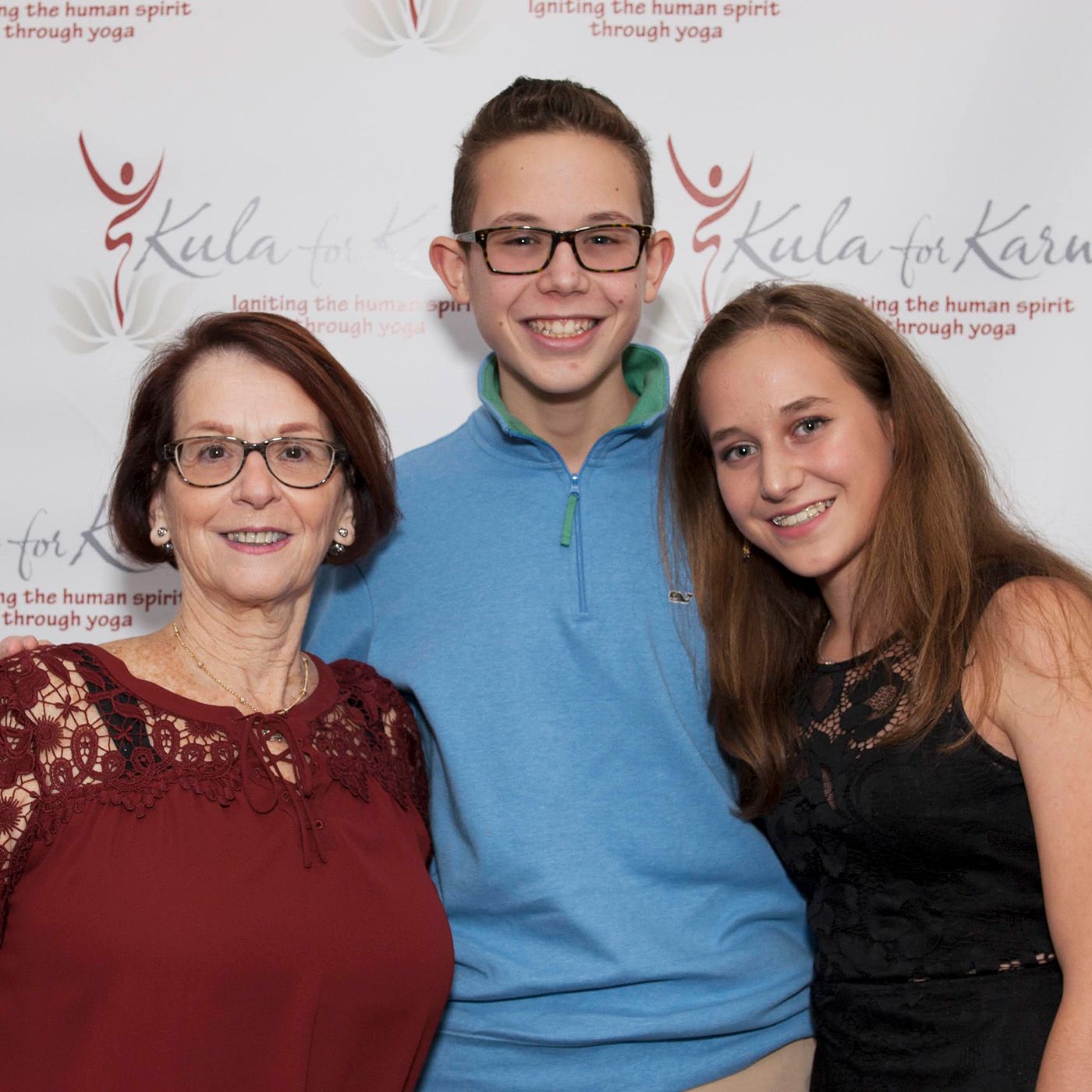 Family photo of three people posing together at a Kula for Karma event.