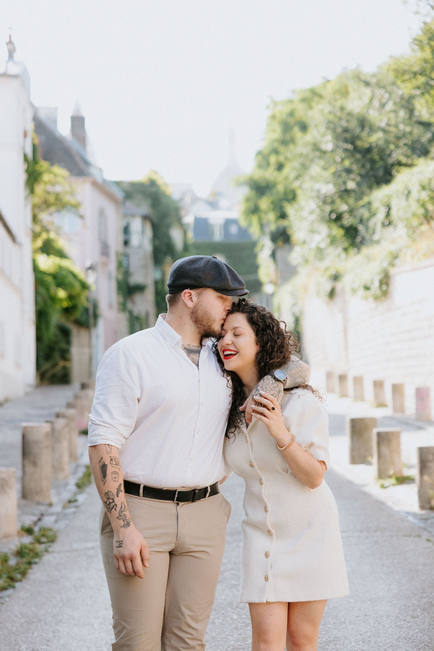 A couple shares an intimate moment while walking together on a charming cobblestone street in Paris.