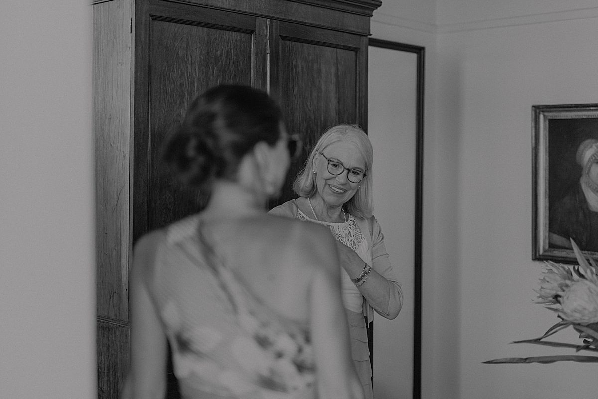 ride adjusting wedding dress in front of mirror, preparing for her big day