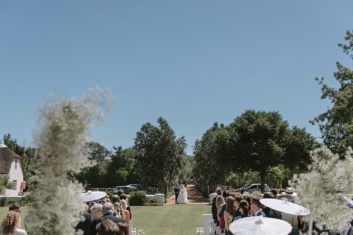 Bride and groom sharing a joyful moment at Weltevreden Estate, with elegant floral arrangements and Cape Dutch architecture.