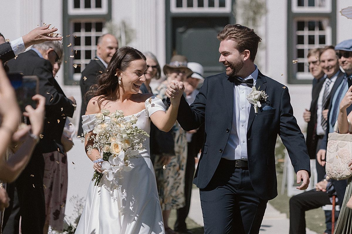 Bride and groom sharing a joyful moment at Weltevreden Estate, with elegant floral arrangements and Cape Dutch architecture.