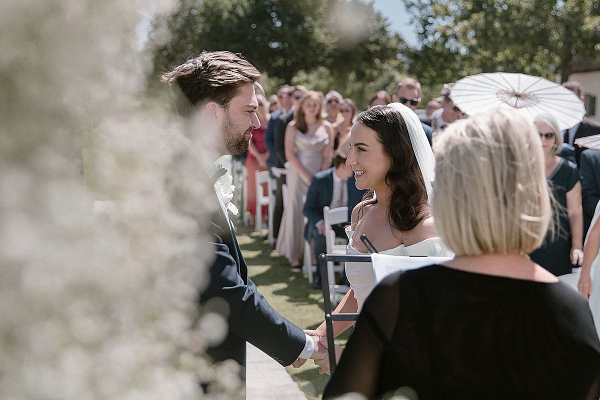 Bride and groom sharing a joyful moment at Weltevreden Estate, with elegant floral arrangements and Cape Dutch architecture.