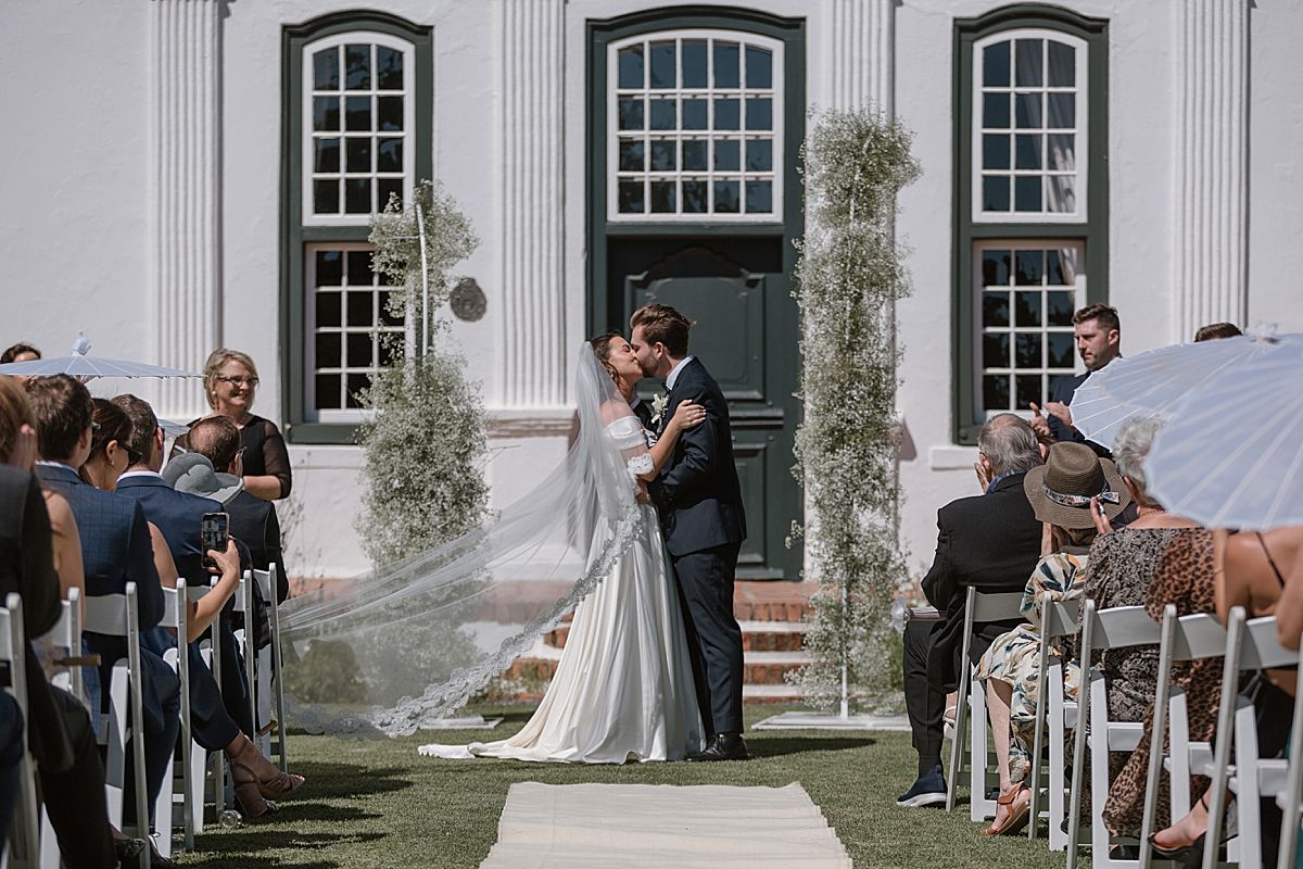 motional moment as couple says “I do” surrounded by family and friends